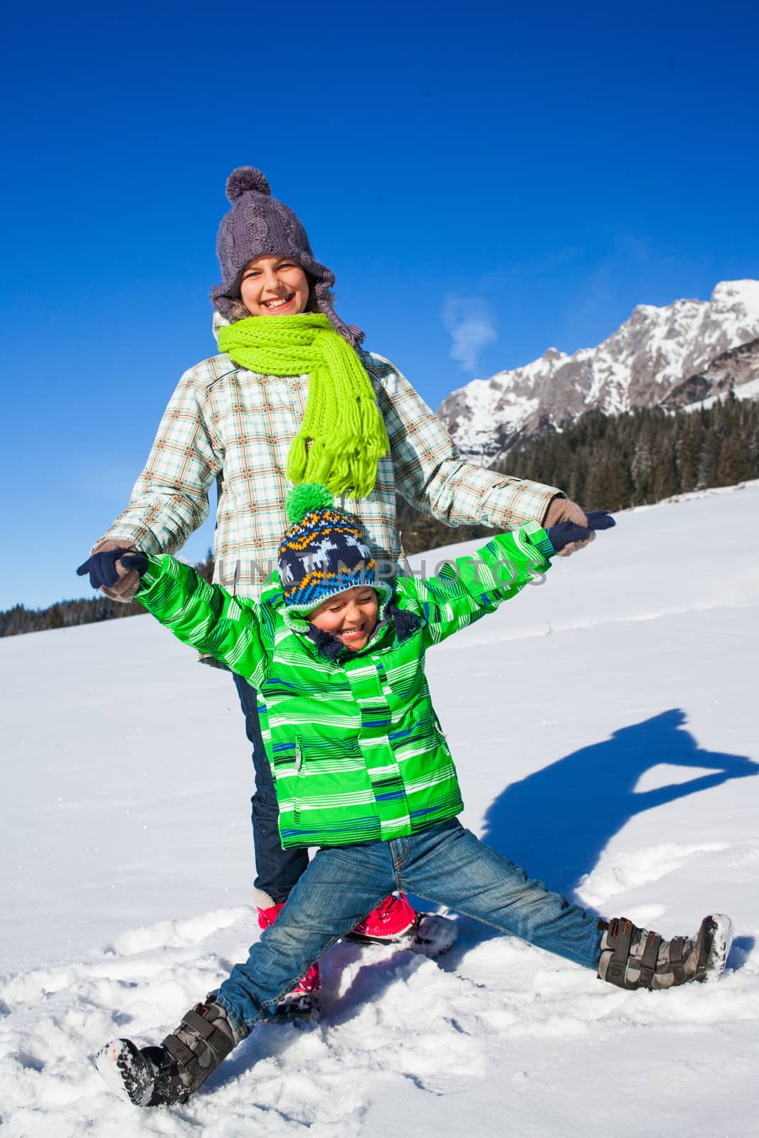 Two happy kids playing winter on the snow in Alps