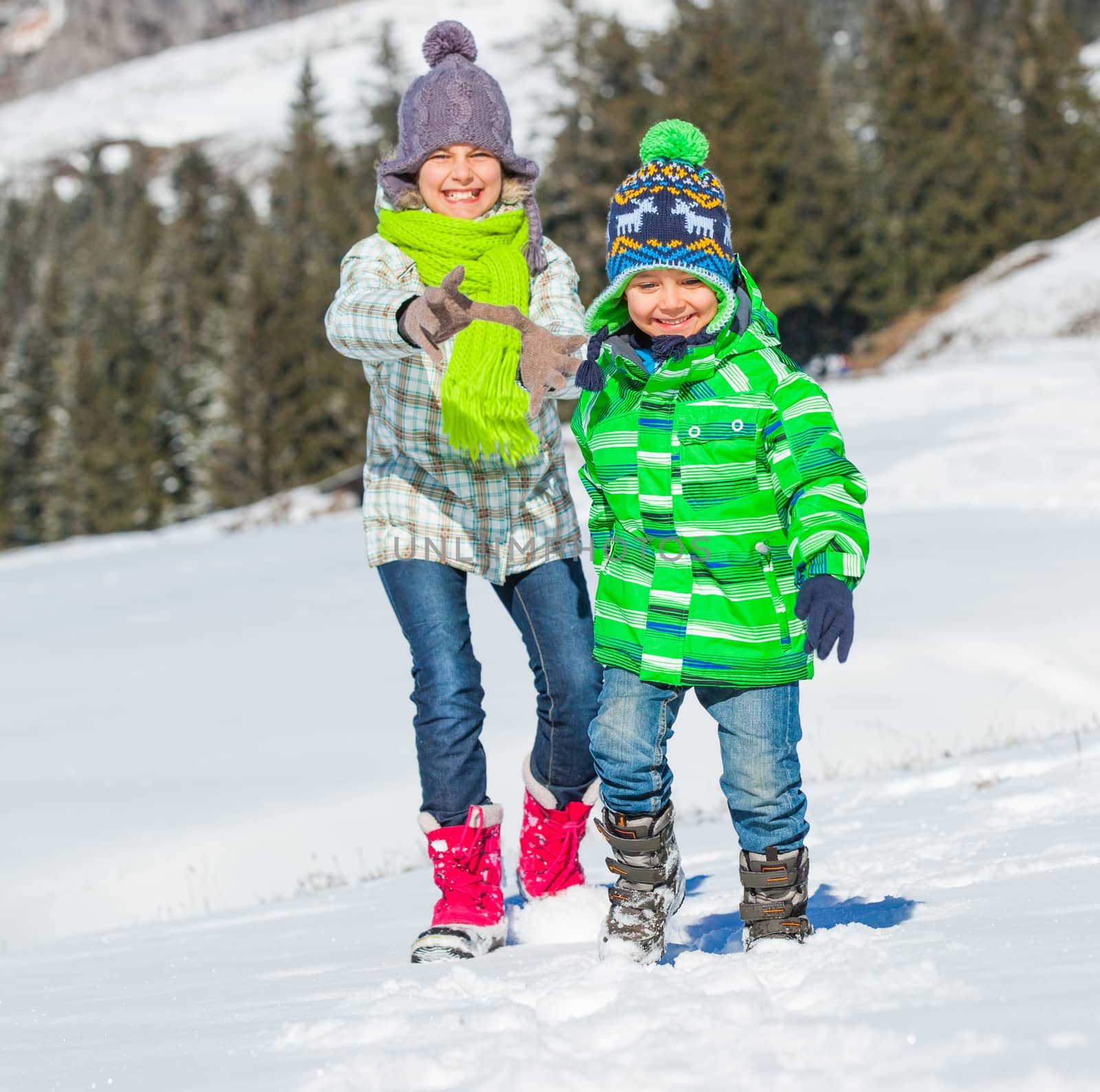 Two happy kids playing winter on the snow in Alps