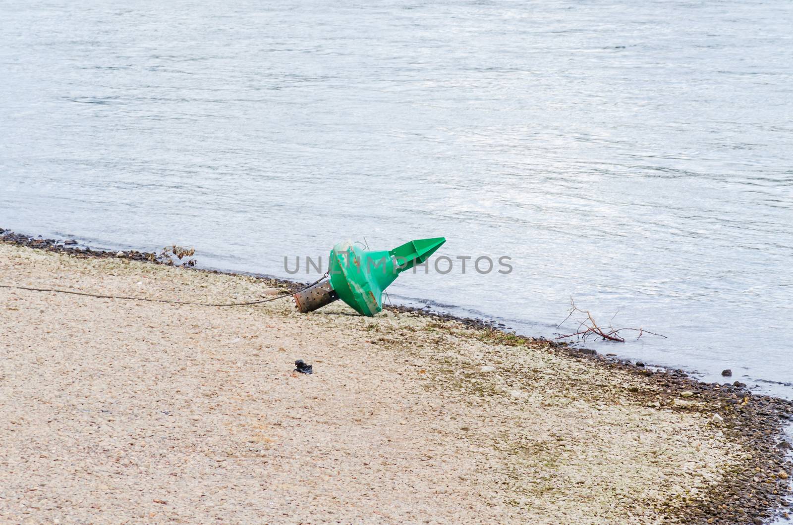Stranded reen fairway buoy on the Rhine.