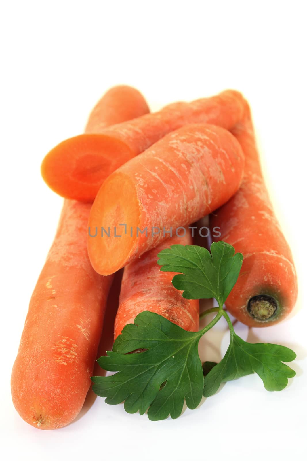orange carrots with parsley against white background