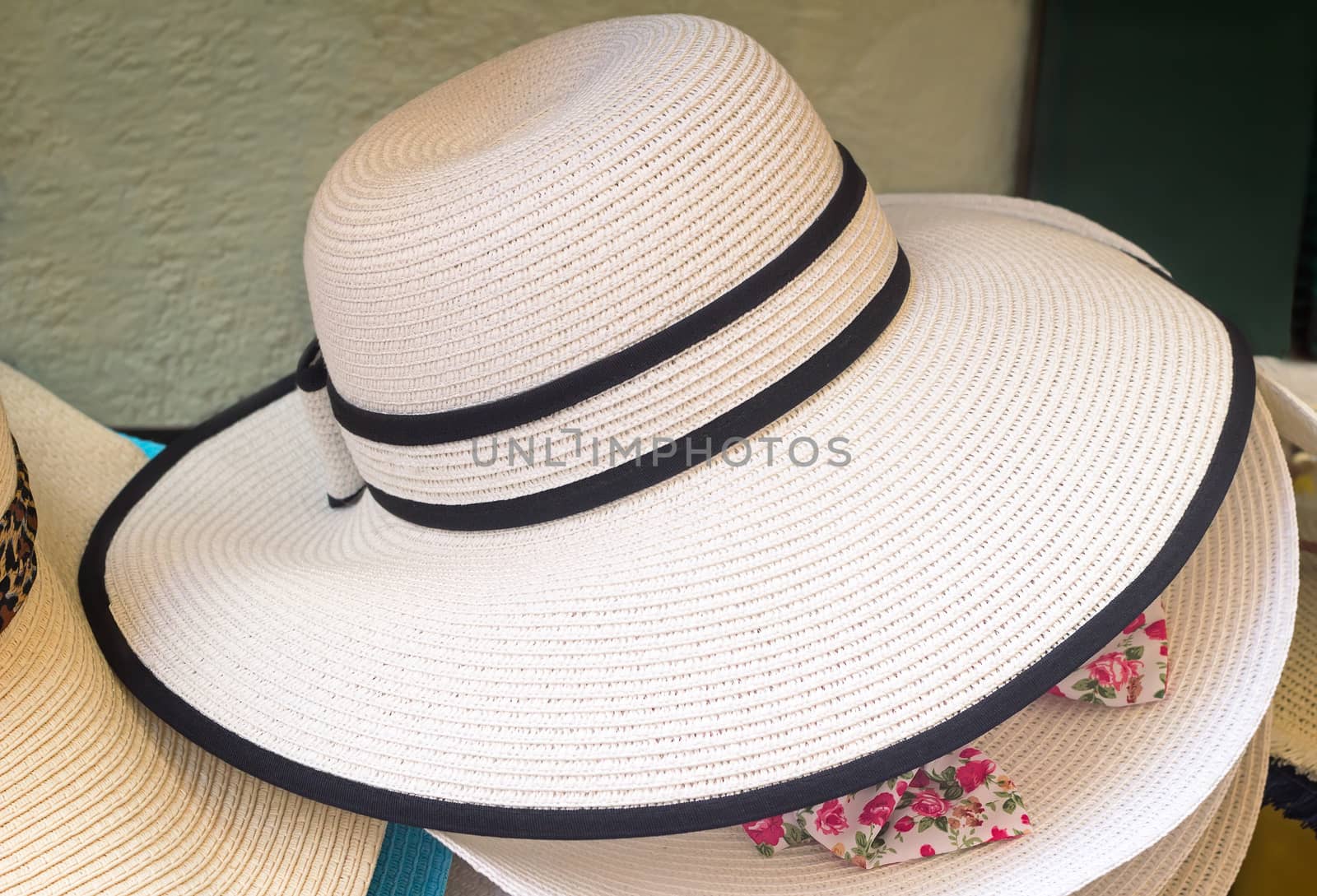 Women's summer hat with large brim, decorated with black ribbon, for protection from the sun.