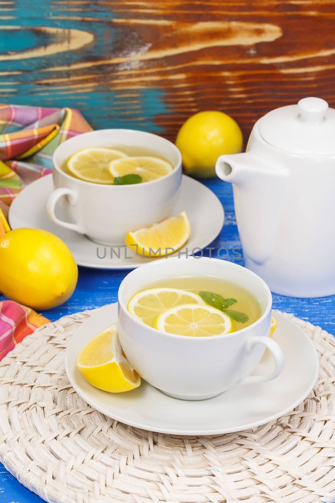 Two cups of tea served with fresh lemon and mint. Macro, selective focus