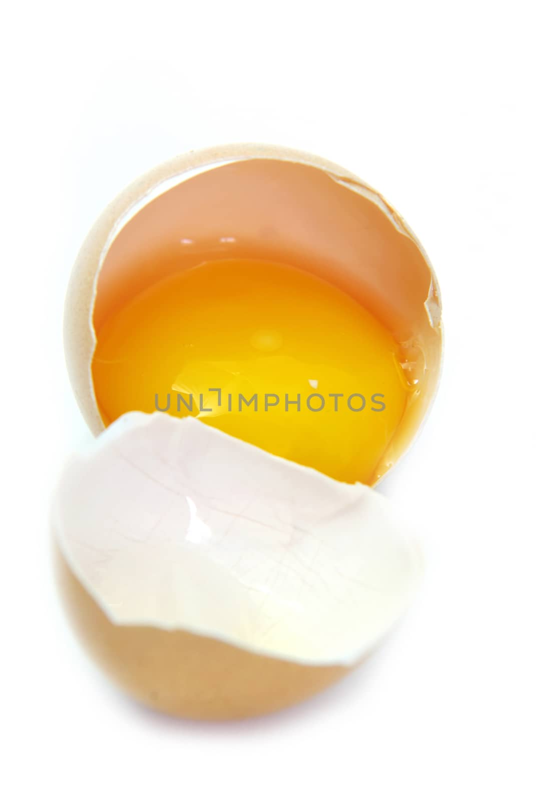 Close up image of a broken egg on white