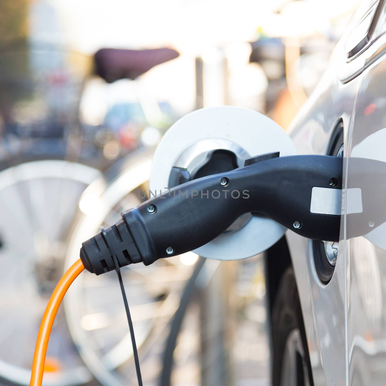 Power supply for electric car charging.  Electric car charging station. Close up of the power supply plugged into an electric car being charged.