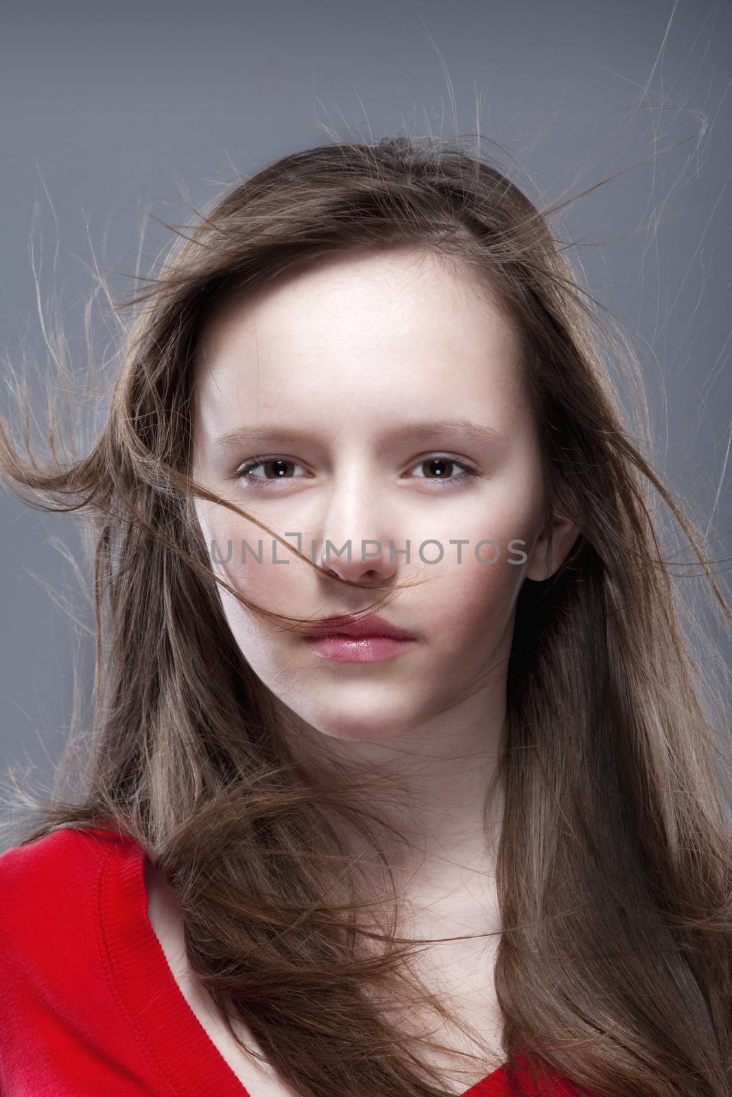 studio shot of an eleven years old girl posing as a fashion model