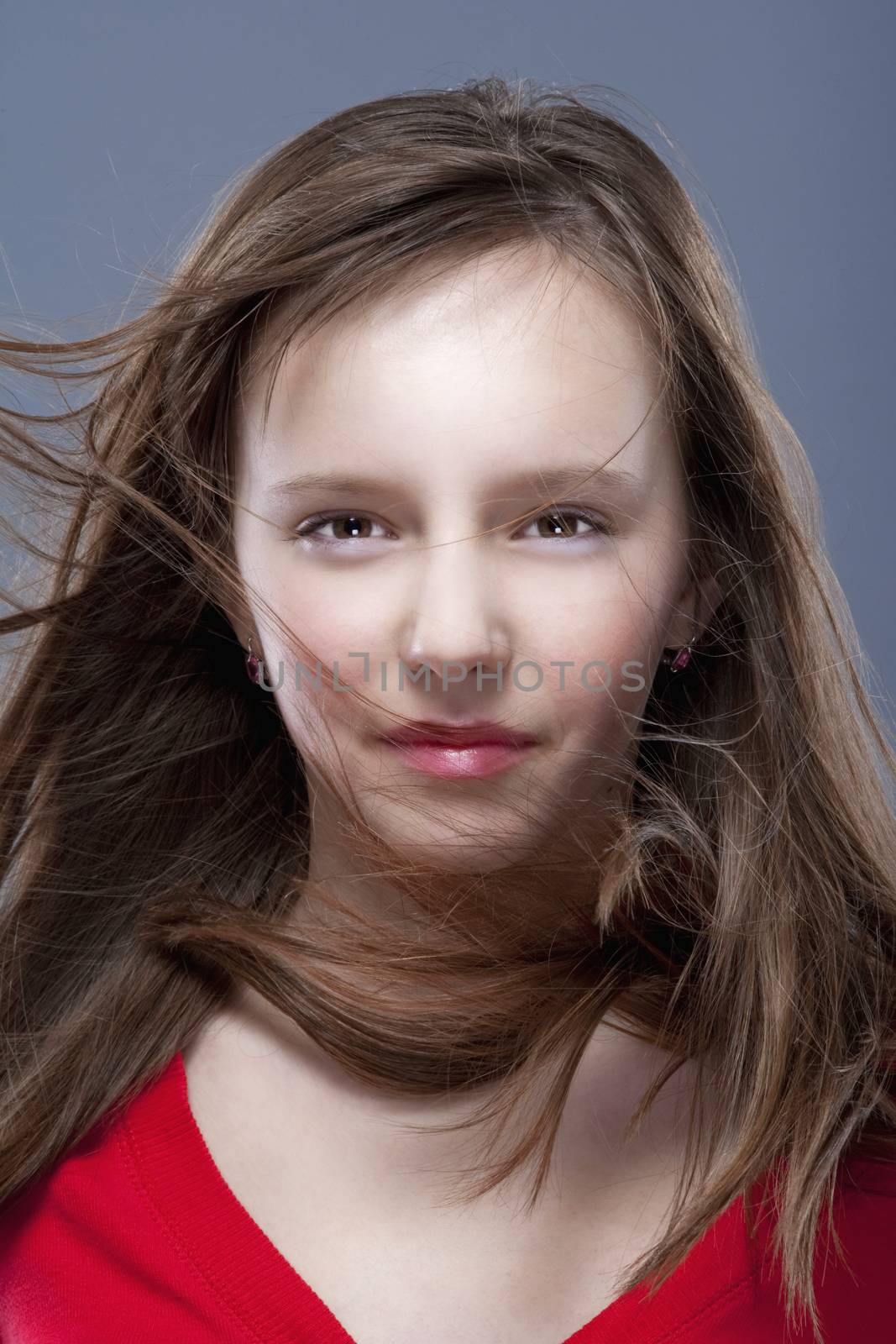 studio shot of an eleven years old girl posing as a fashion model