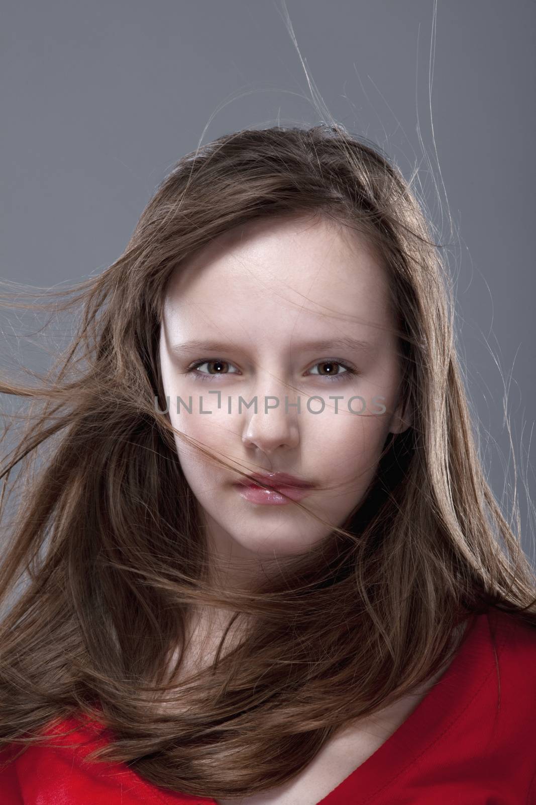 studio shot of an eleven years old girl posing as a fashion model