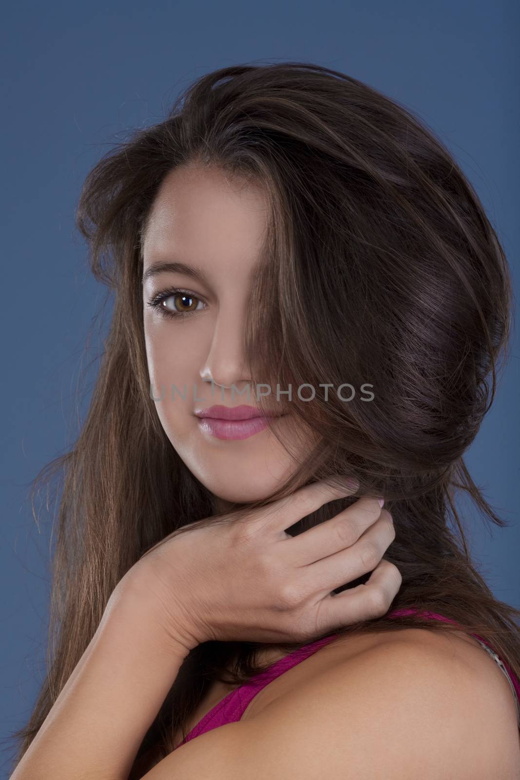 studio portrait of a beautiful brunette isolated on blue background