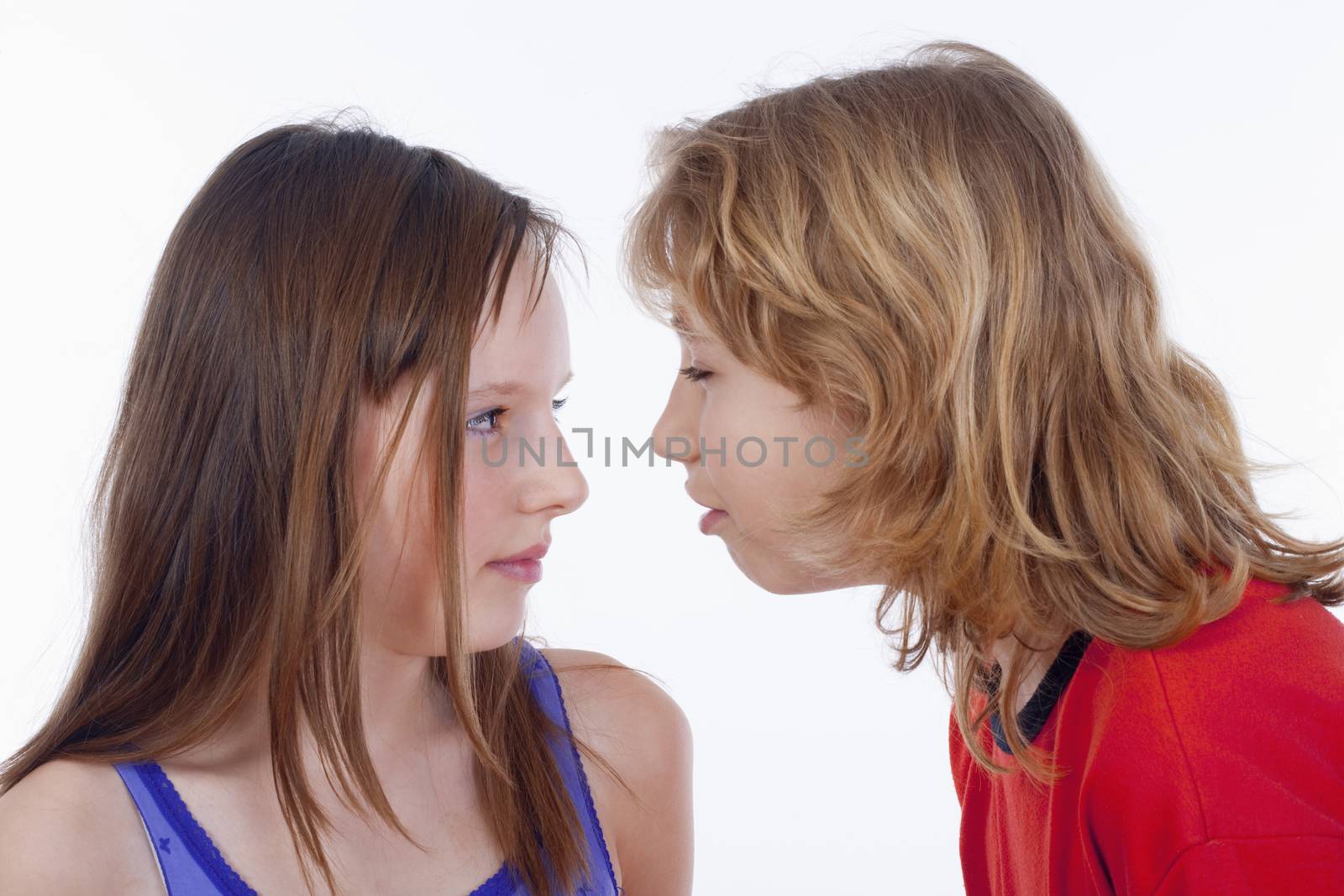young boy and girl standing close talking - isolated on white