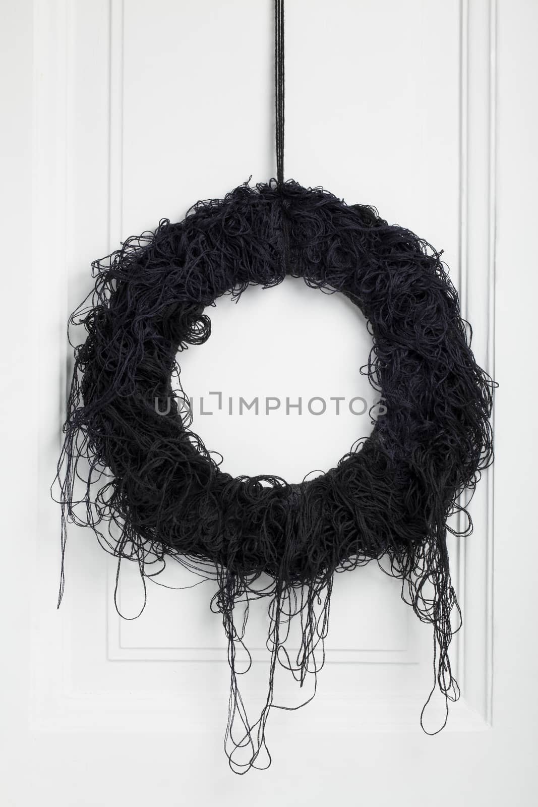 Scaring black twig wreath, decorated with dangling threads.