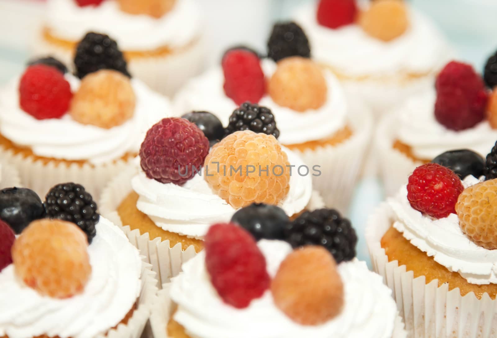 Cupcakes with white cream and berries