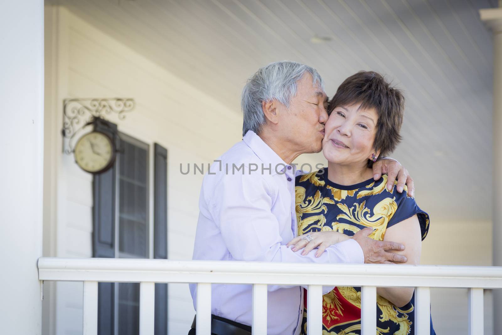 Attractive Happy Chinese Couple Enjoying Their House Outside.