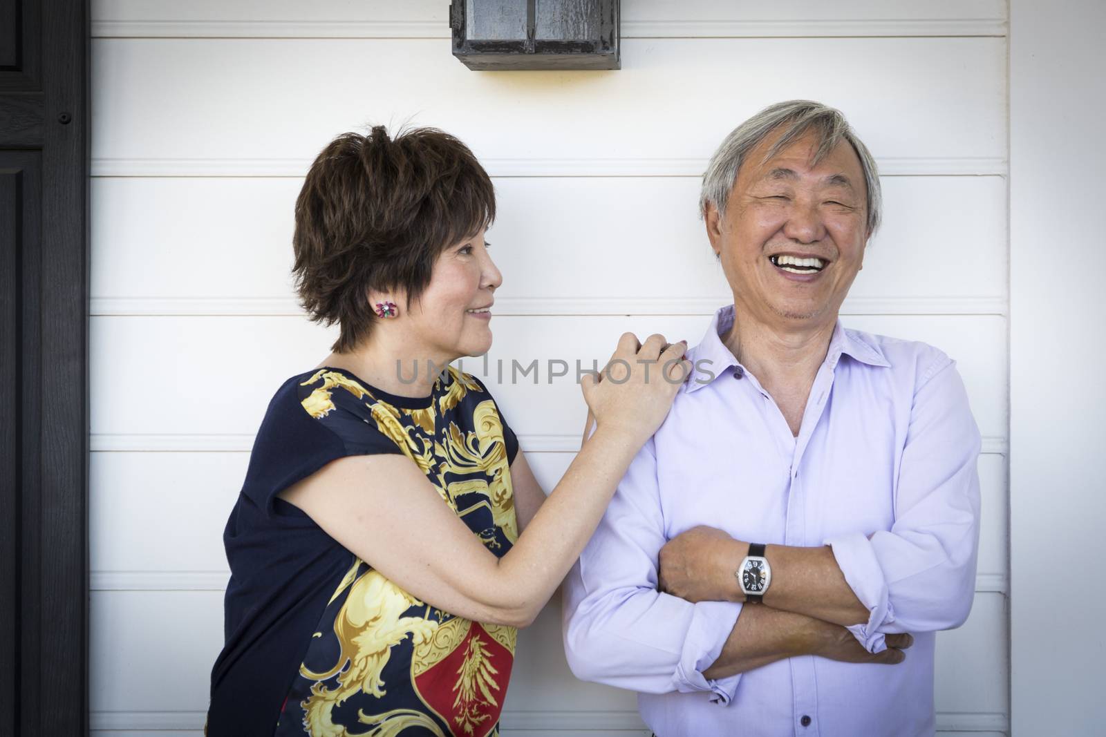 Attractive Happy Chinese Couple Enjoying Their House Outside.