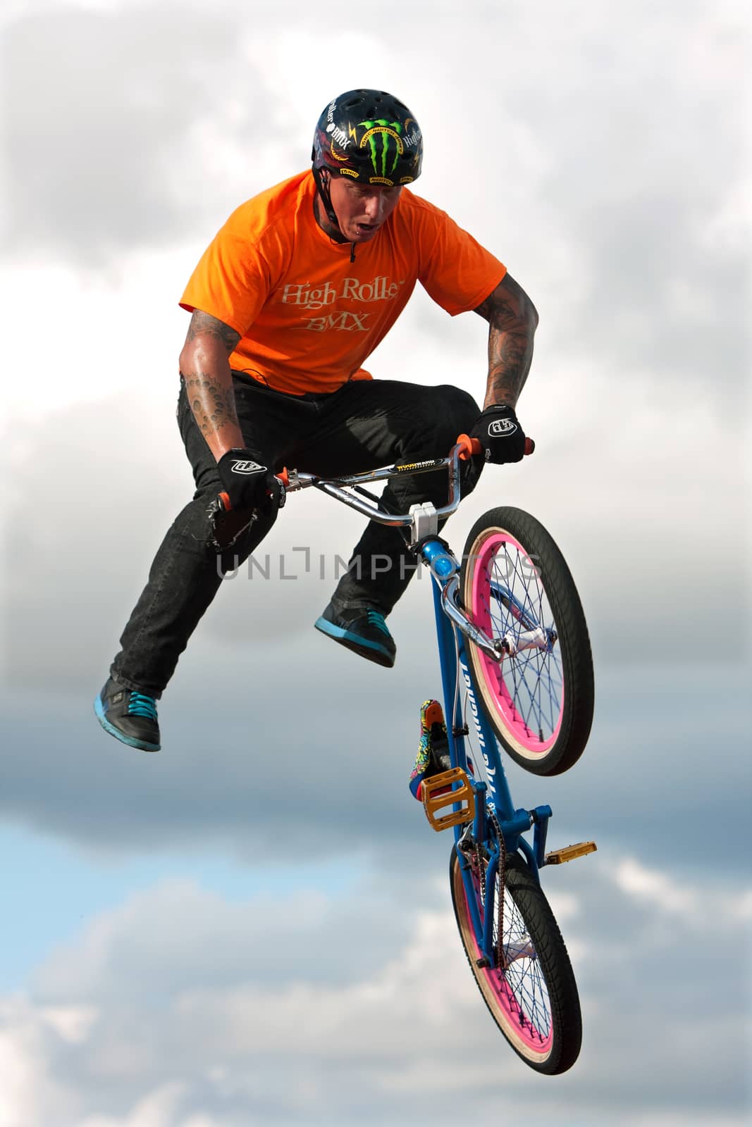 Hampton, GA, USA - September 27, 2014:  A young man with the High Roller BMX club rotates his bike in midair while performing a BMX stunt at the Georgia State Fair.