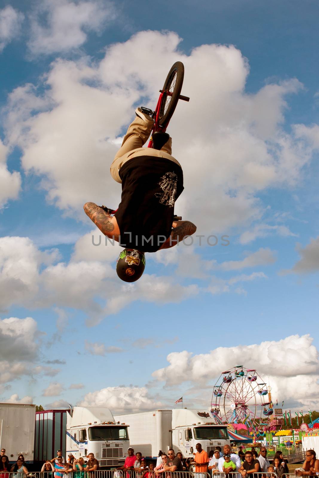 Hampton, GA, USA - September 27, 2014:  A young man with the High Roller BMX club flips upside down while performing a BMX stunt at the Georgia State Fair. 
