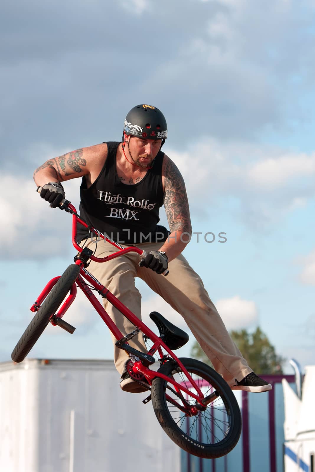 Hampton, GA, USA - September 27, 2014:  A young man with the High Roller BMX club spins his bike in midair while performing a BMX stunt at the Georgia State Fair.