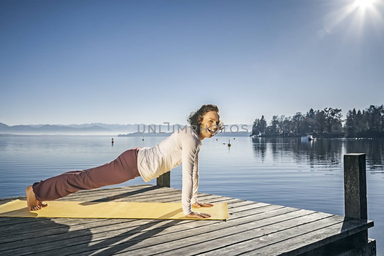 An image of a pretty woman doing yoga at the lake