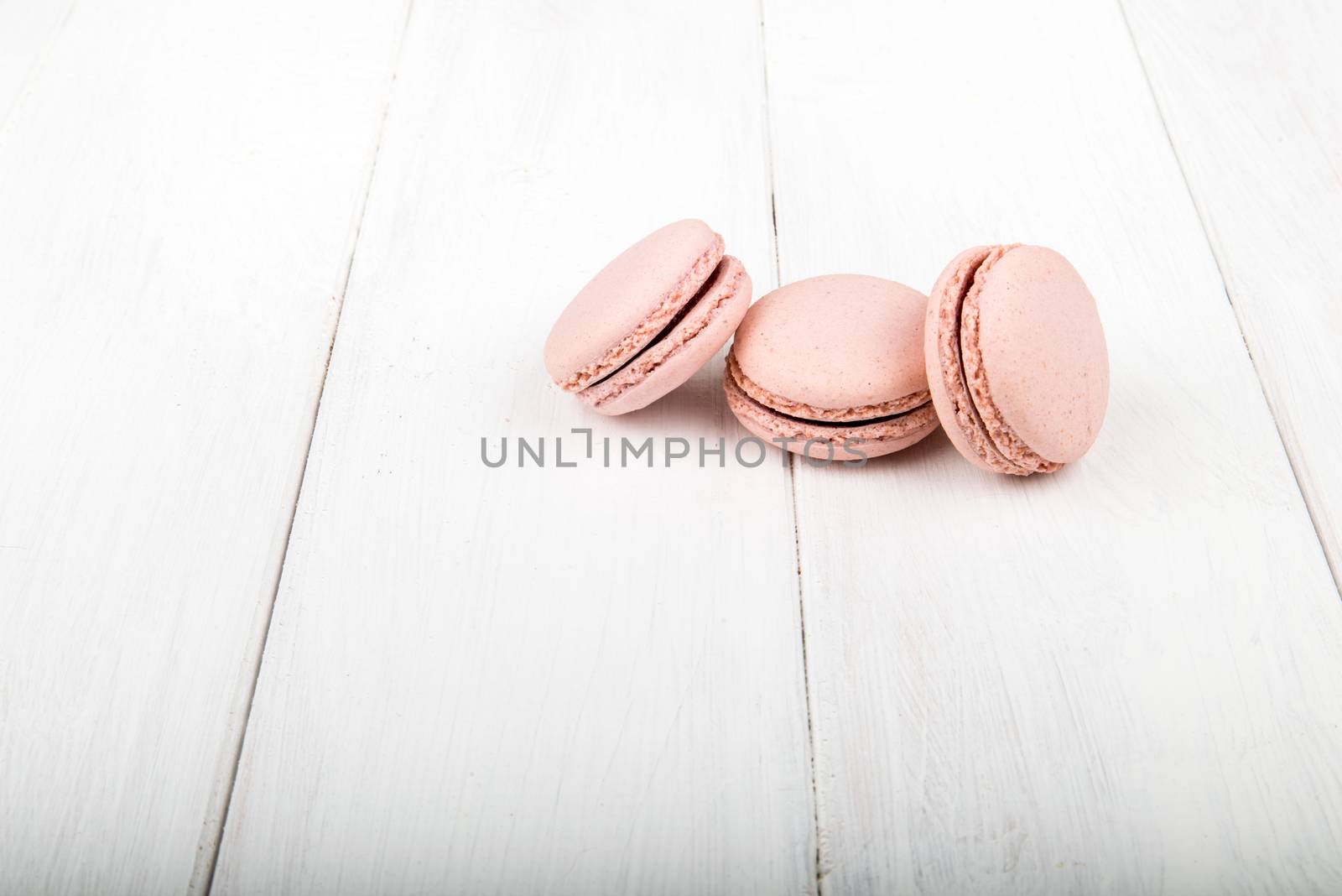 Set of macarons isolated on white wooden table