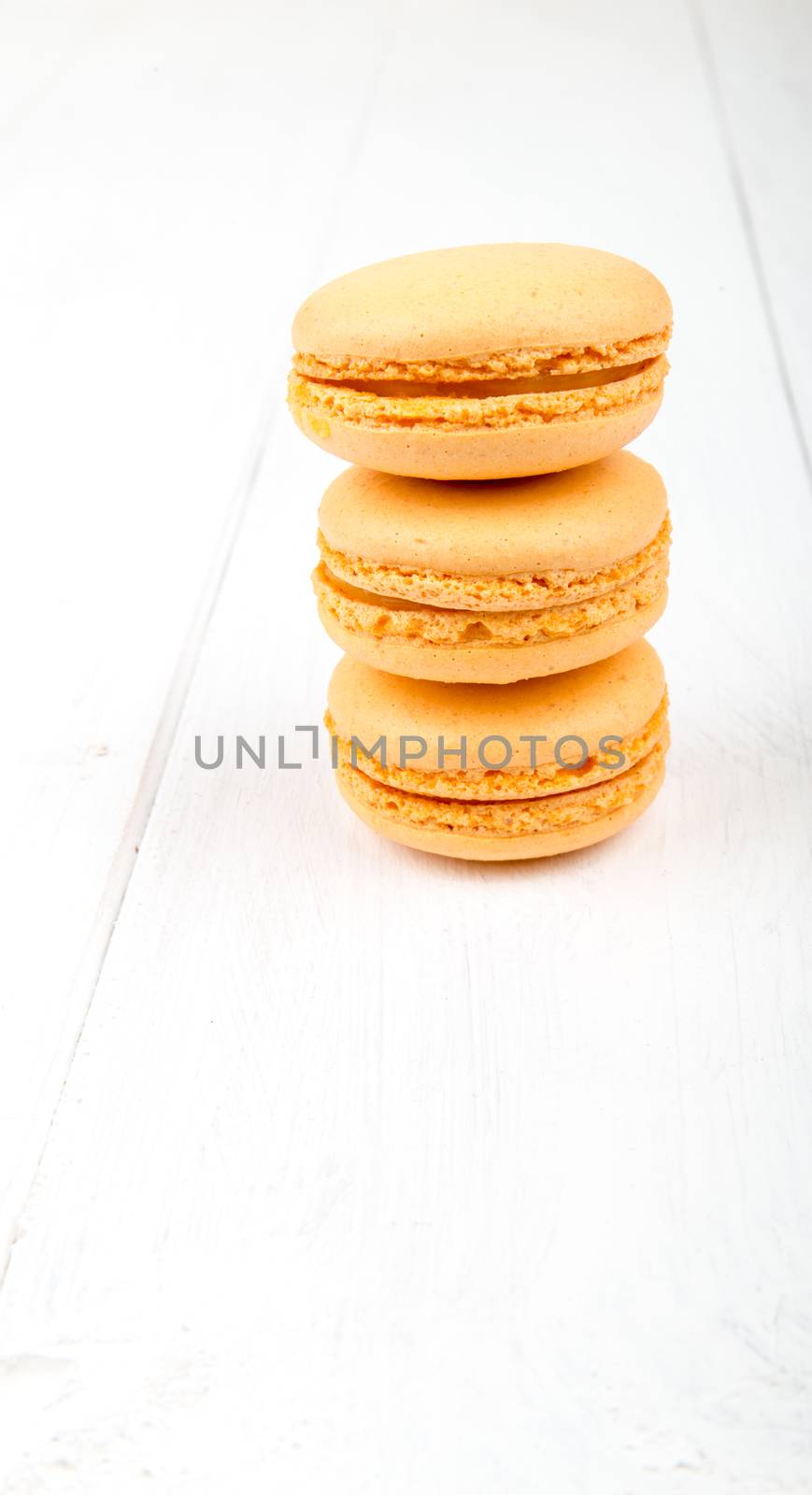 Set of macarons on white wooden table by marius_dragne