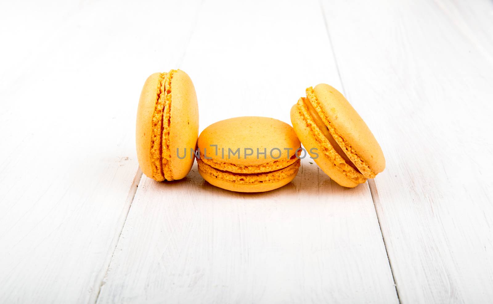 Set of macarons isolated on white wooden table