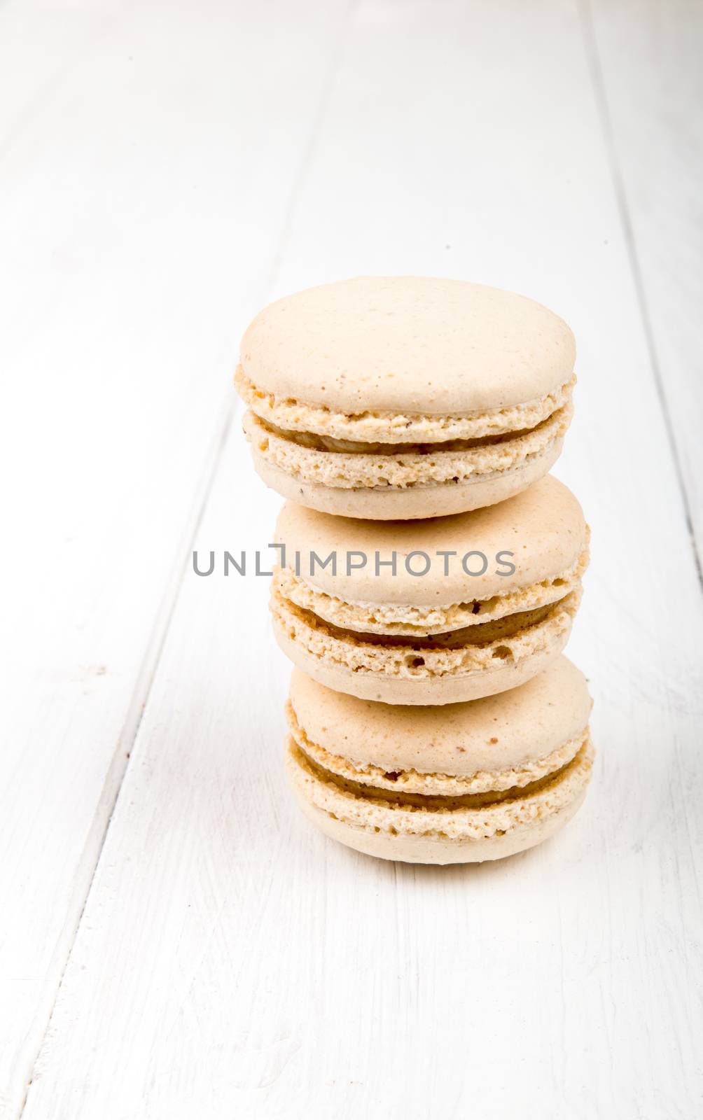 Set of macarons on white wooden table by marius_dragne