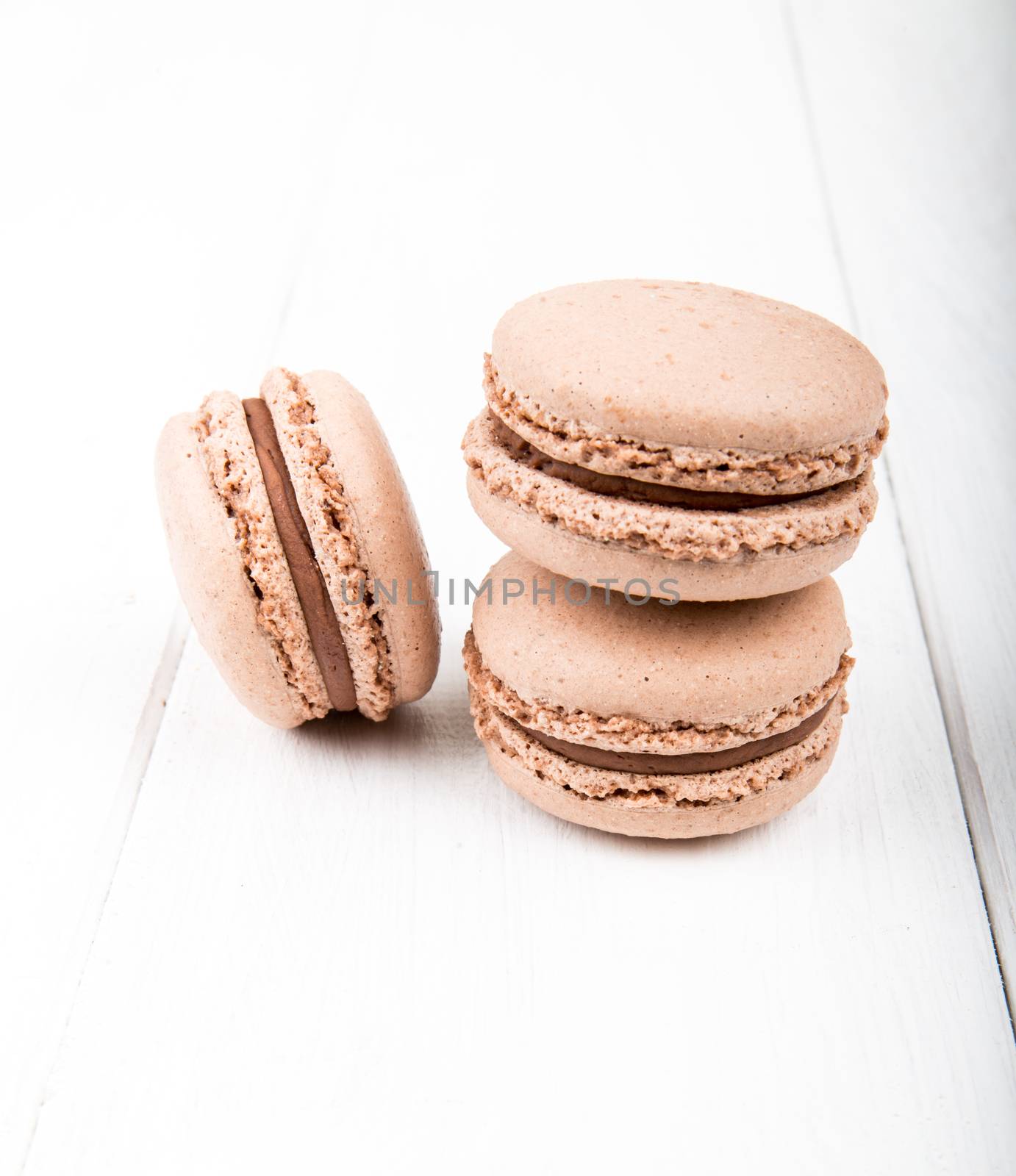 Set of macarons isolated on white wooden table