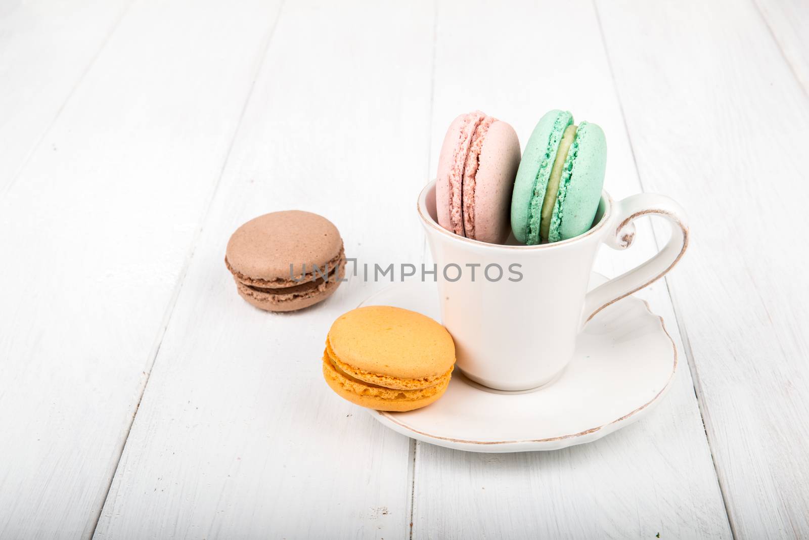 Set of macarons isolated on white wooden table