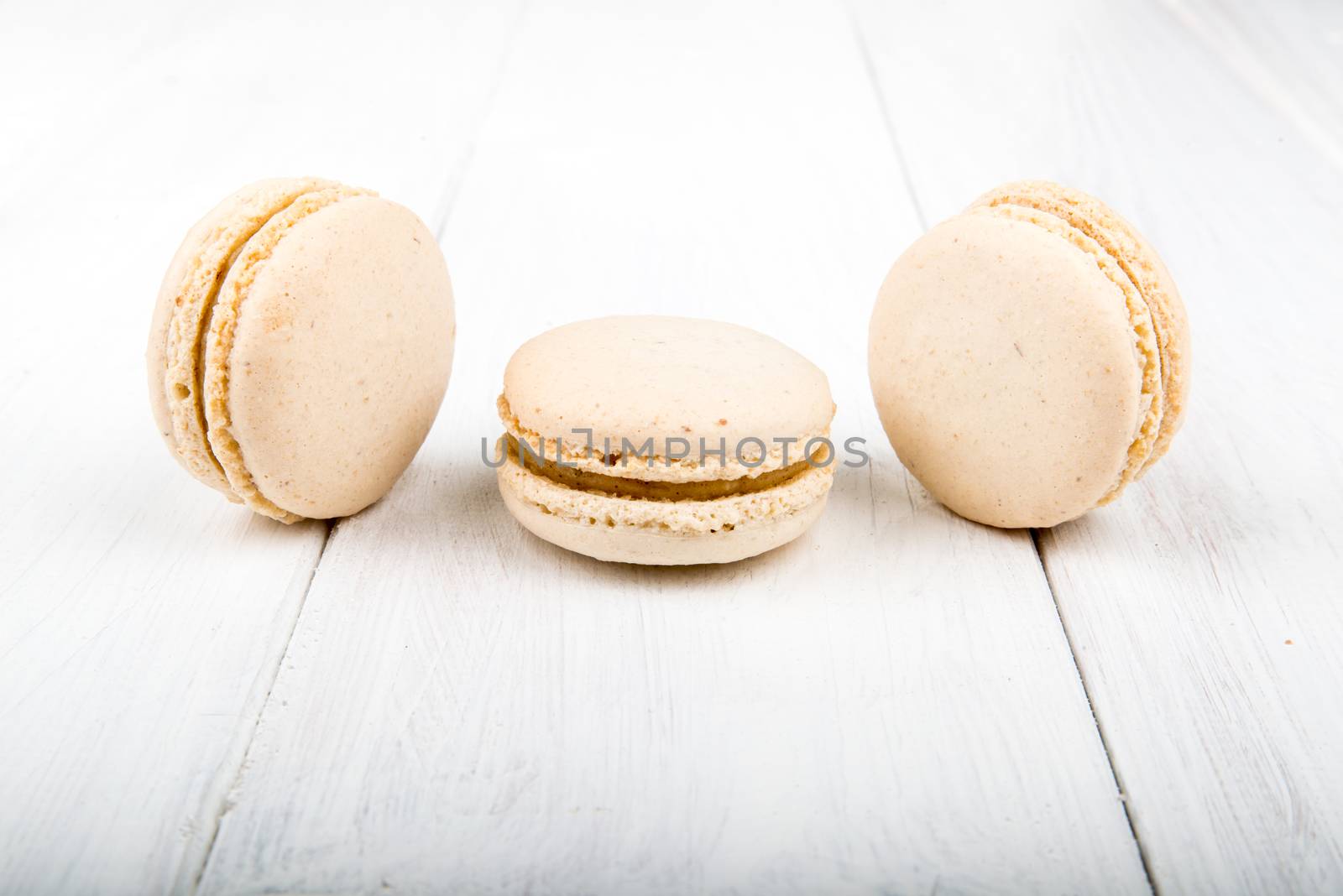 Set of macarons isolated on white wooden table