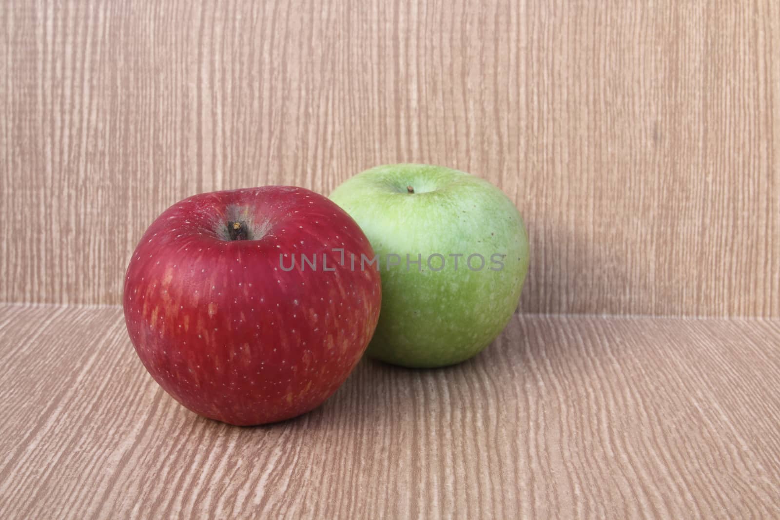 red apple and green on wooden background .