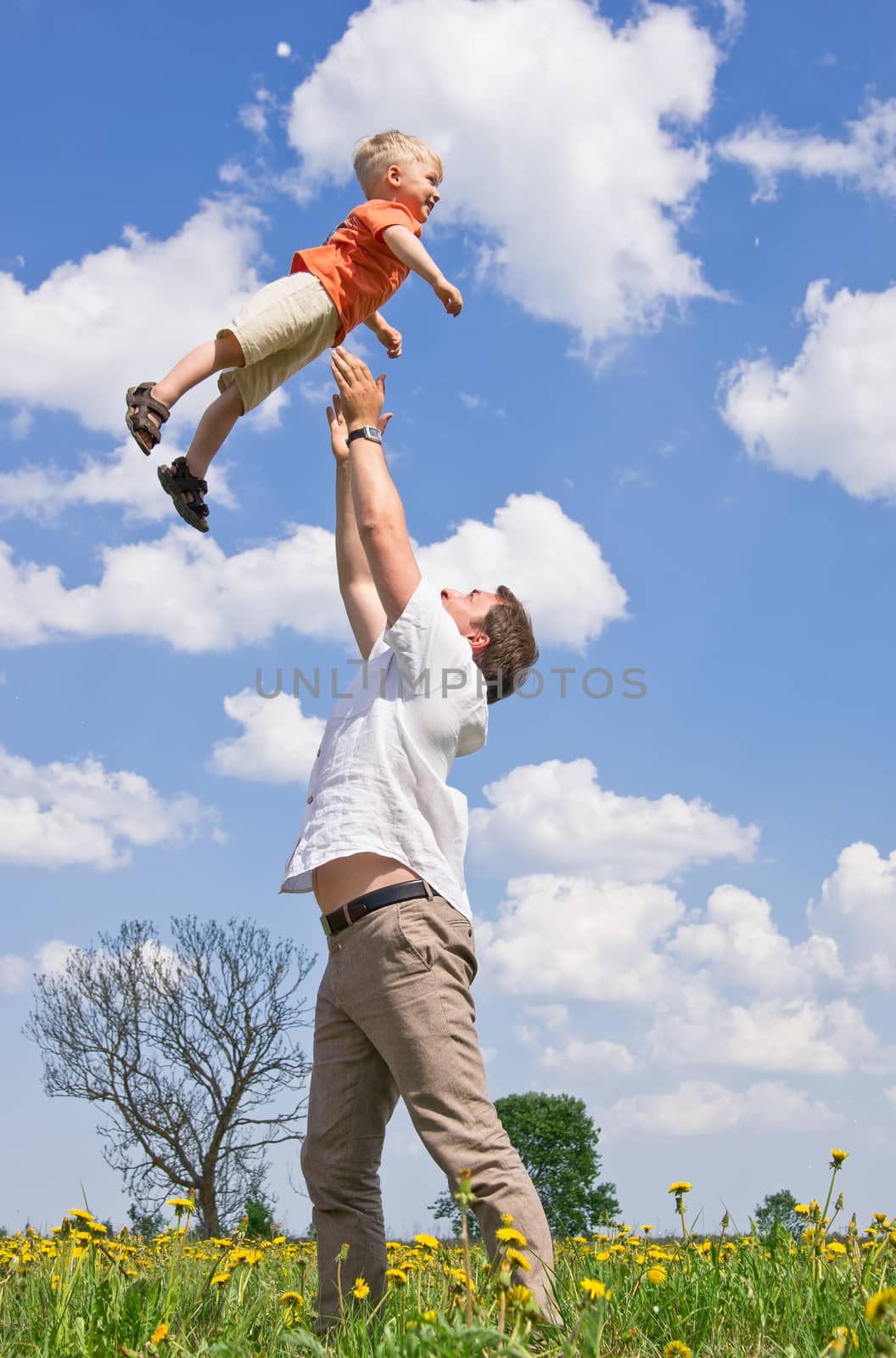 Father playing with son on meadow