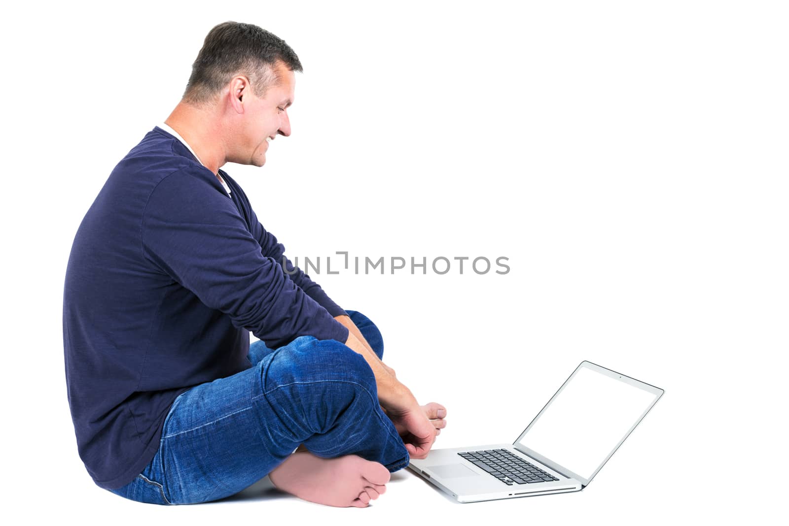 Casually dressed middle aged man with laptop.  Sitting man shot in horizontal format isolated on white.