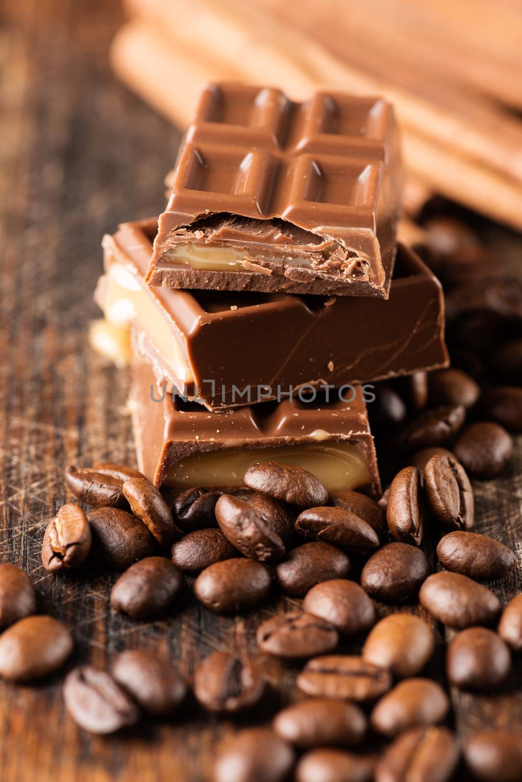 Coffee beans with chocolate bar on wooden table