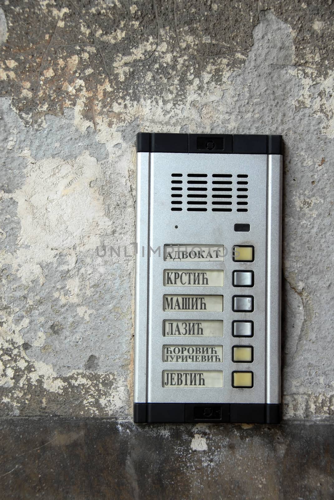 metallic interphone on old wall with serbian surnames