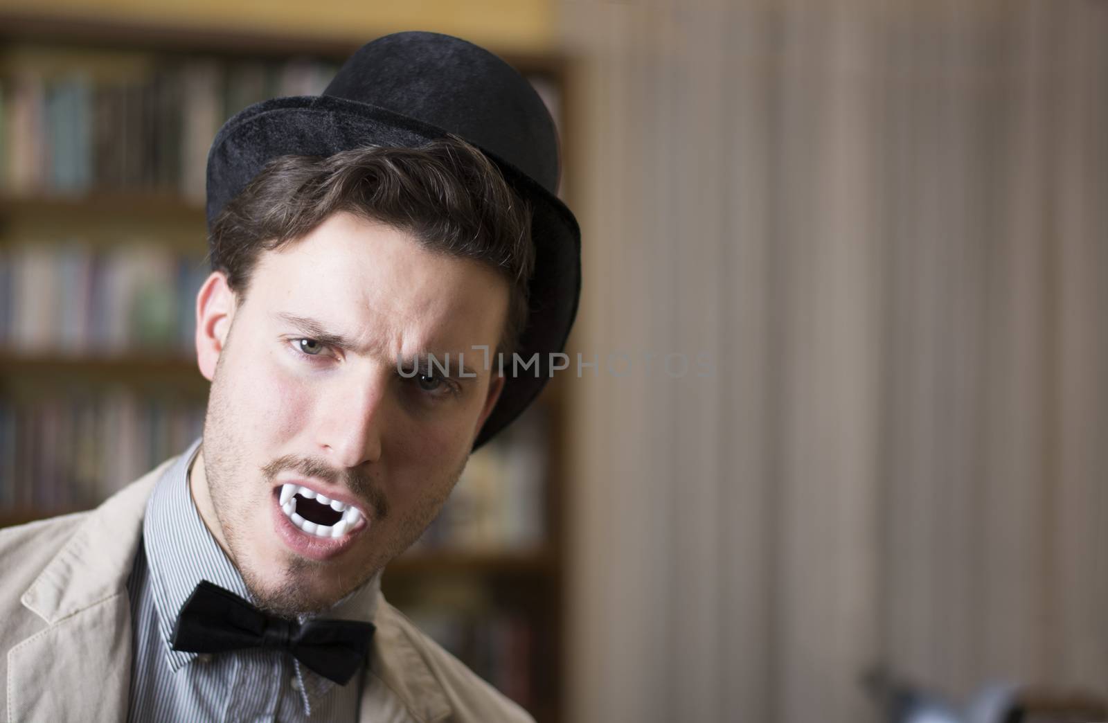 Close up Young Handsome White Vampire with Black Top Hat Inside the Mini Library