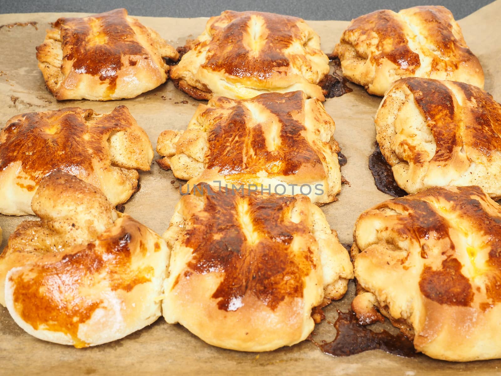 Fresh made cinnamon buns plaited on baking paper by Arvebettum