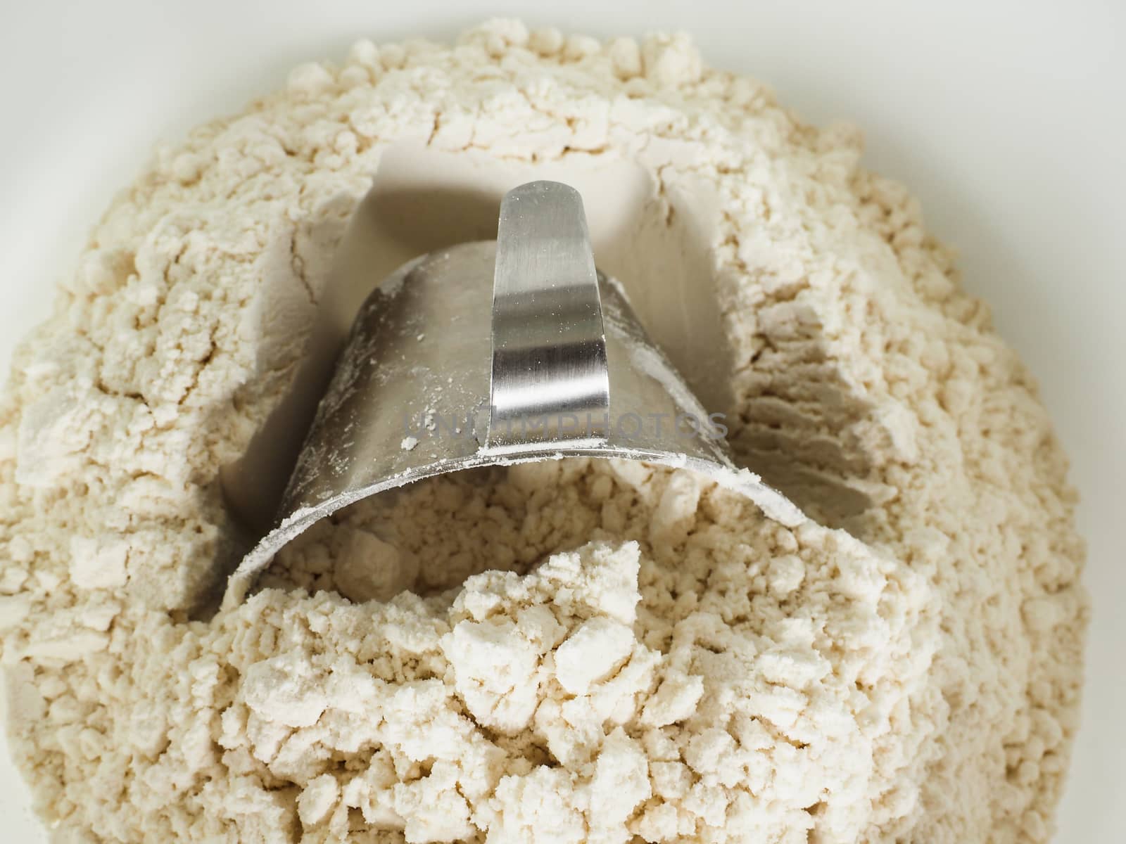Measurement tool in a bowl of wheat flour by Arvebettum