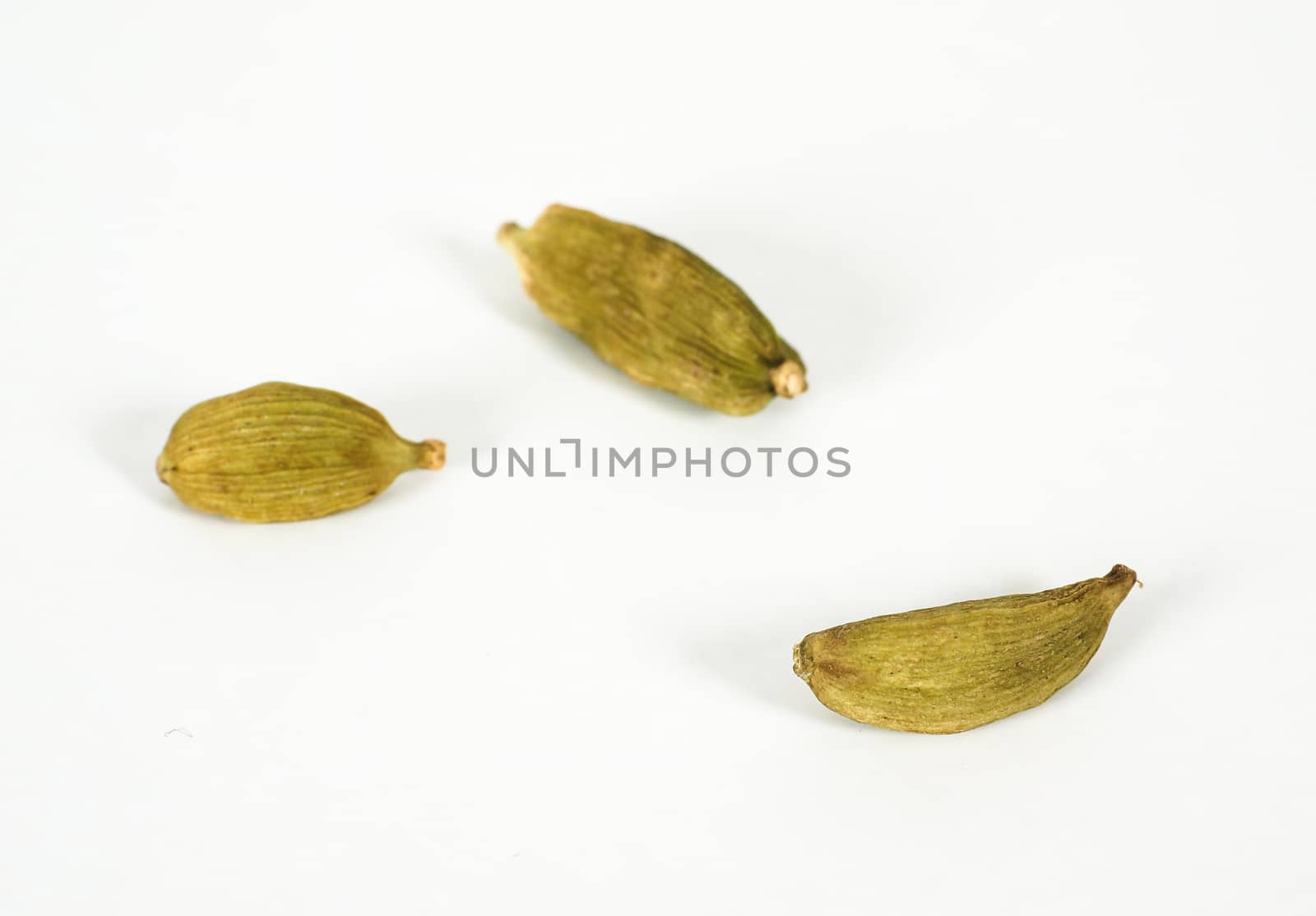 Whole cardamom isolated on grey scale background by Arvebettum