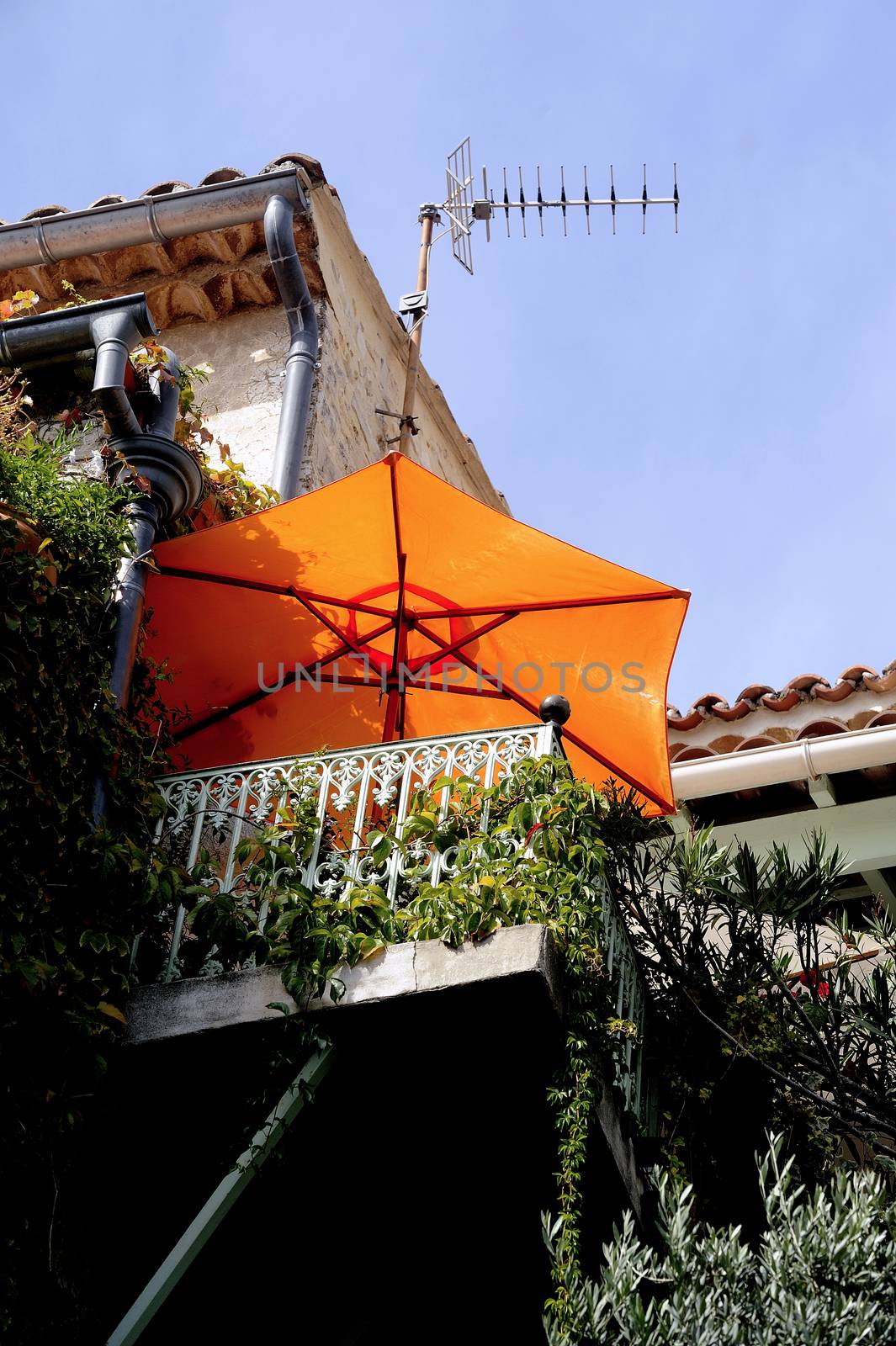 Parasol on the terrace of an old stone house French village Vezenobres