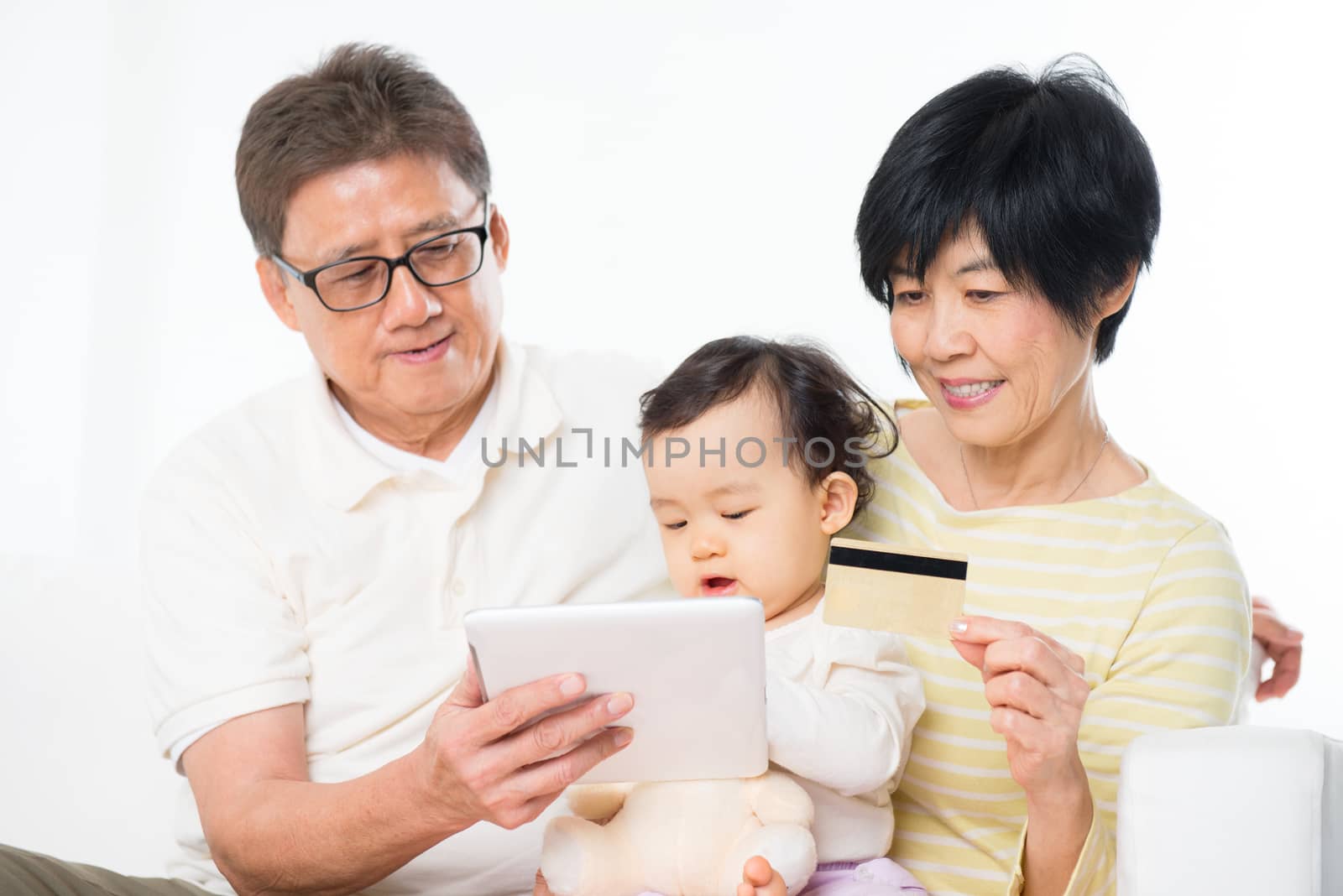 Asian family online shopping indoor, grandparents and grandchild living lifestyle at home.