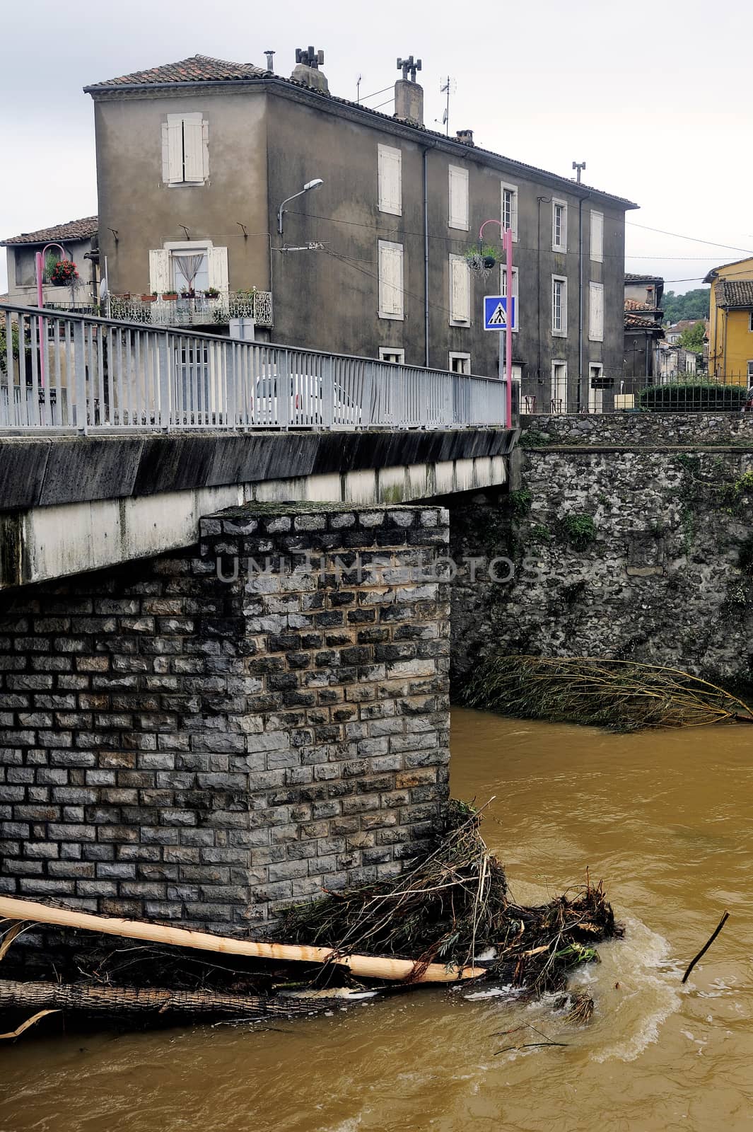 Saint-Hippolyte-du-Fort, a small French town in the foothills of the Cevennes Gard along the river Vidourle The swollen after heavy rains trees have blocked the bridge pier.