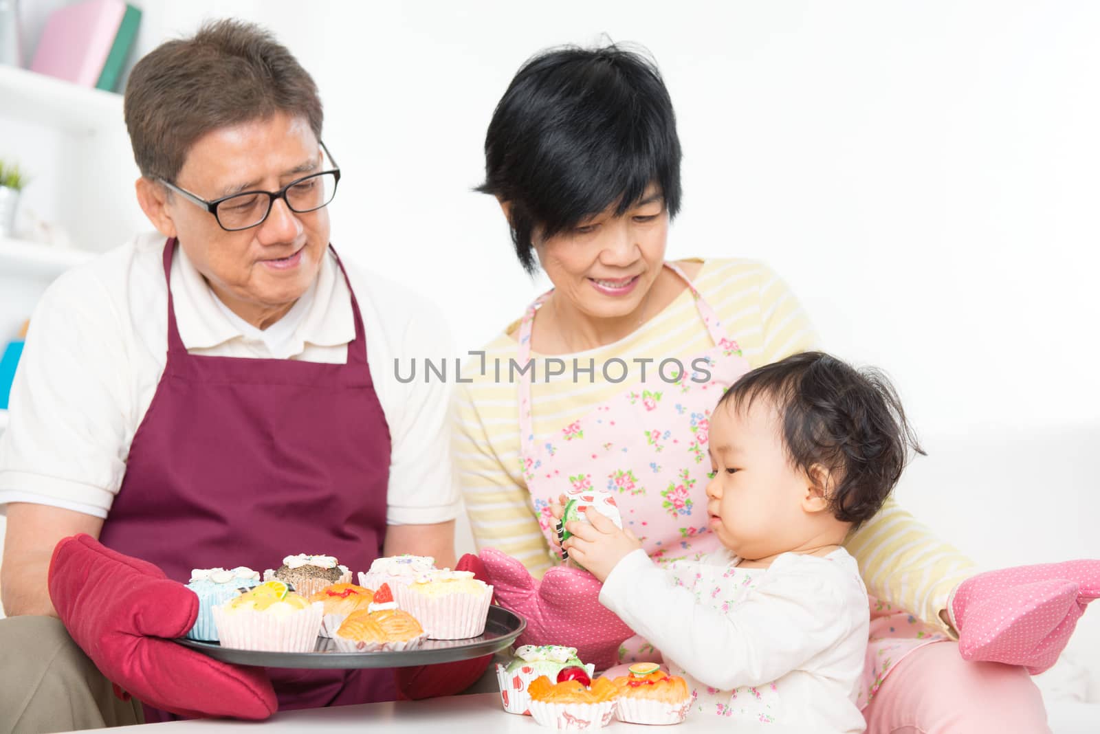 Asian family baking cake, grandparents and grandchild indoor living lifestyle at home.
