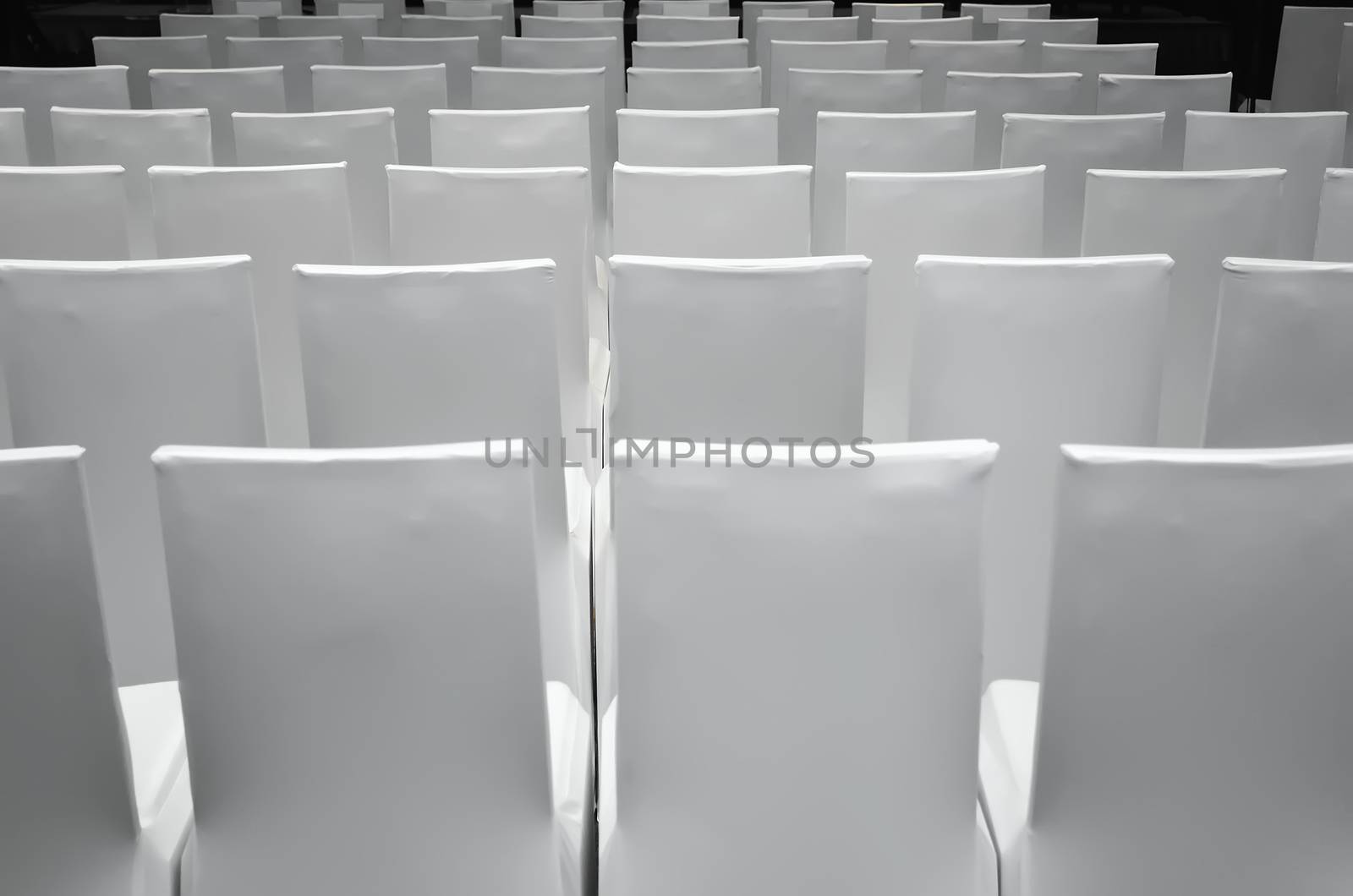 Rows of white chair inside a corporate function room