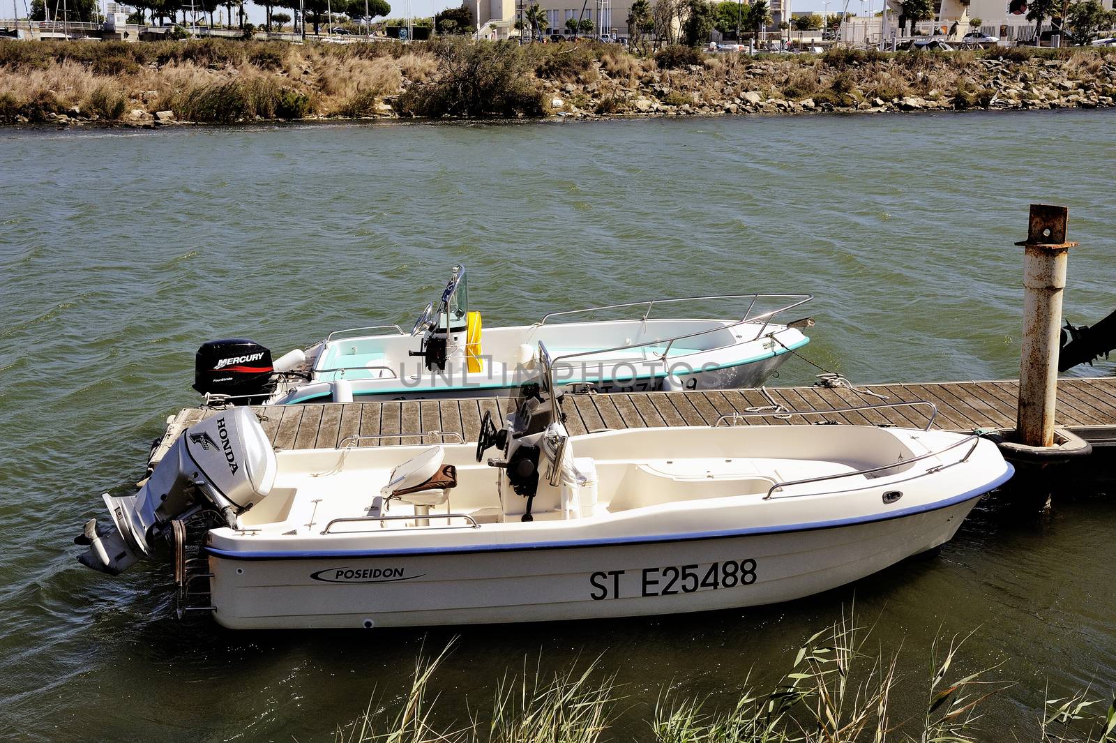 Small motor boat dock waiting to go out for a walk along the canal Le Grau-du-Roi in the Camargue