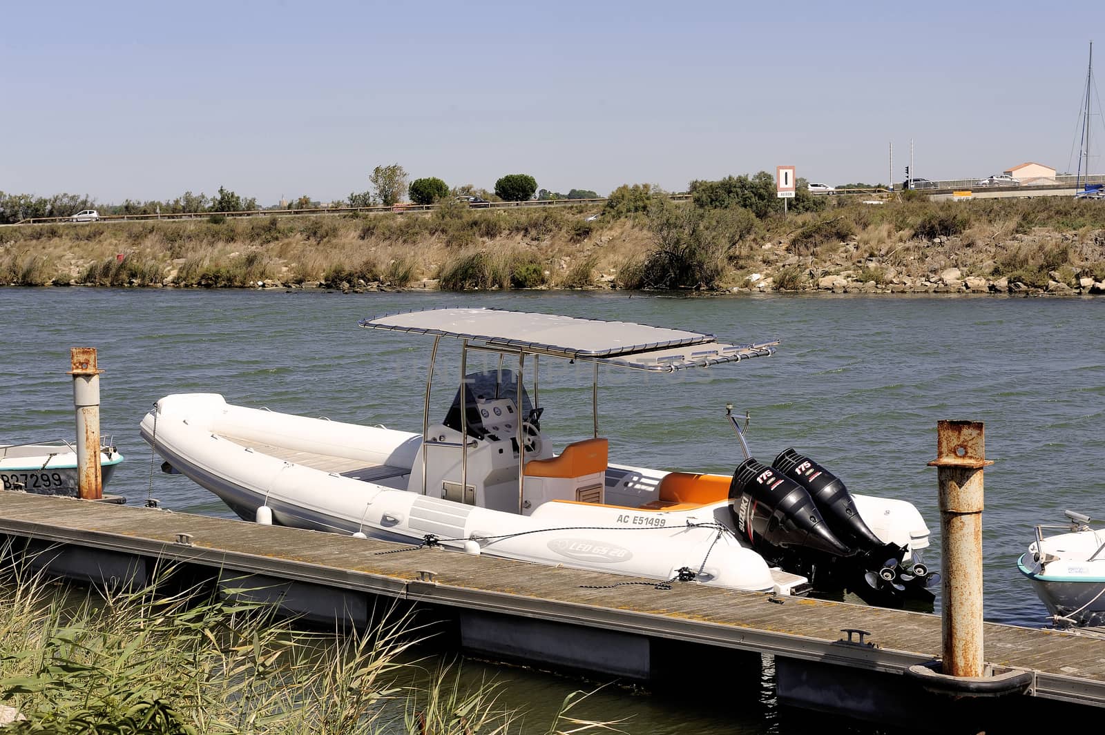 Small motor boat dock waiting to go out for a walk along the canal Le Grau-du-Roi in the Camargue