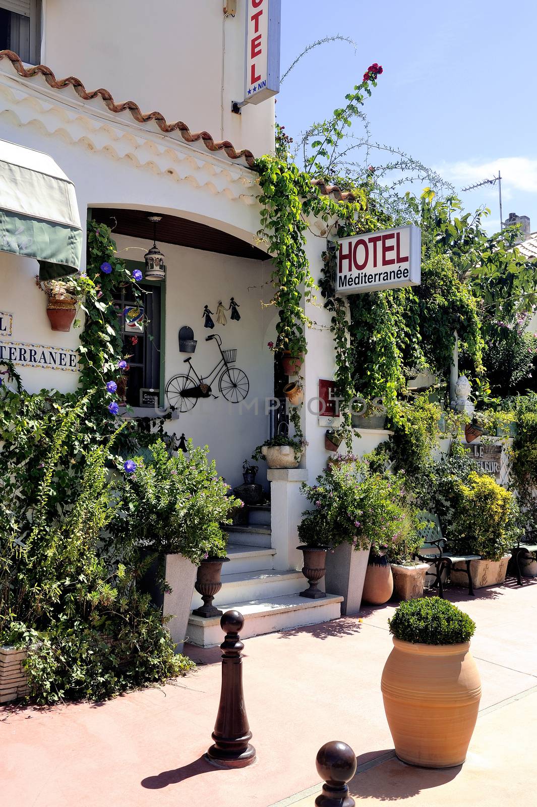 facade of a nice little hotel in Saintes-Maries-de-la-Mer in the city center.