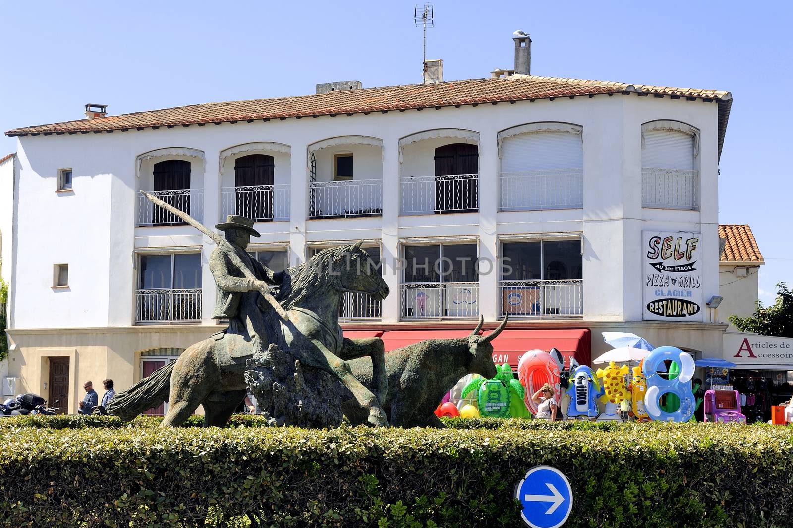 Statue of Guardian guiding a bull on the roundabout to the city center Camarguaise city of Saintes-Maries-de-la-Mer.