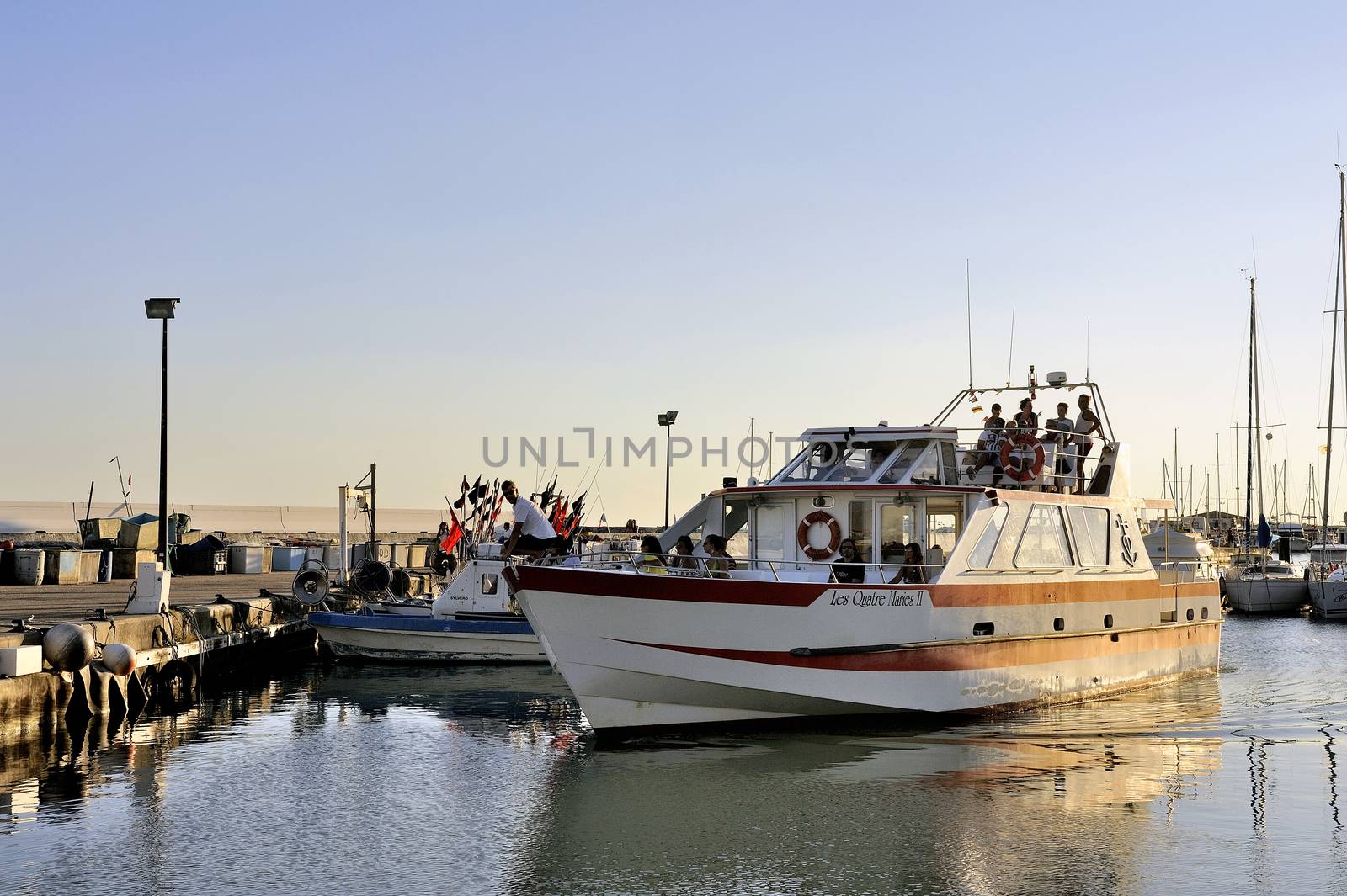 Sightseeing boat in the Sea of Saintes-Maries-de-la-Mer returning to port to unload its passengers.