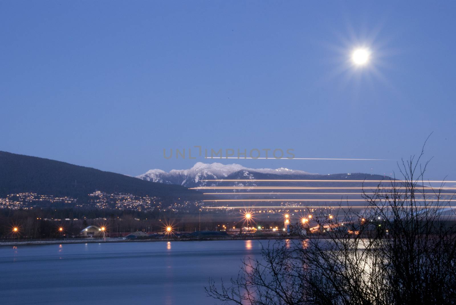 Night scene of downtown Vancouver with boat pass by lighting