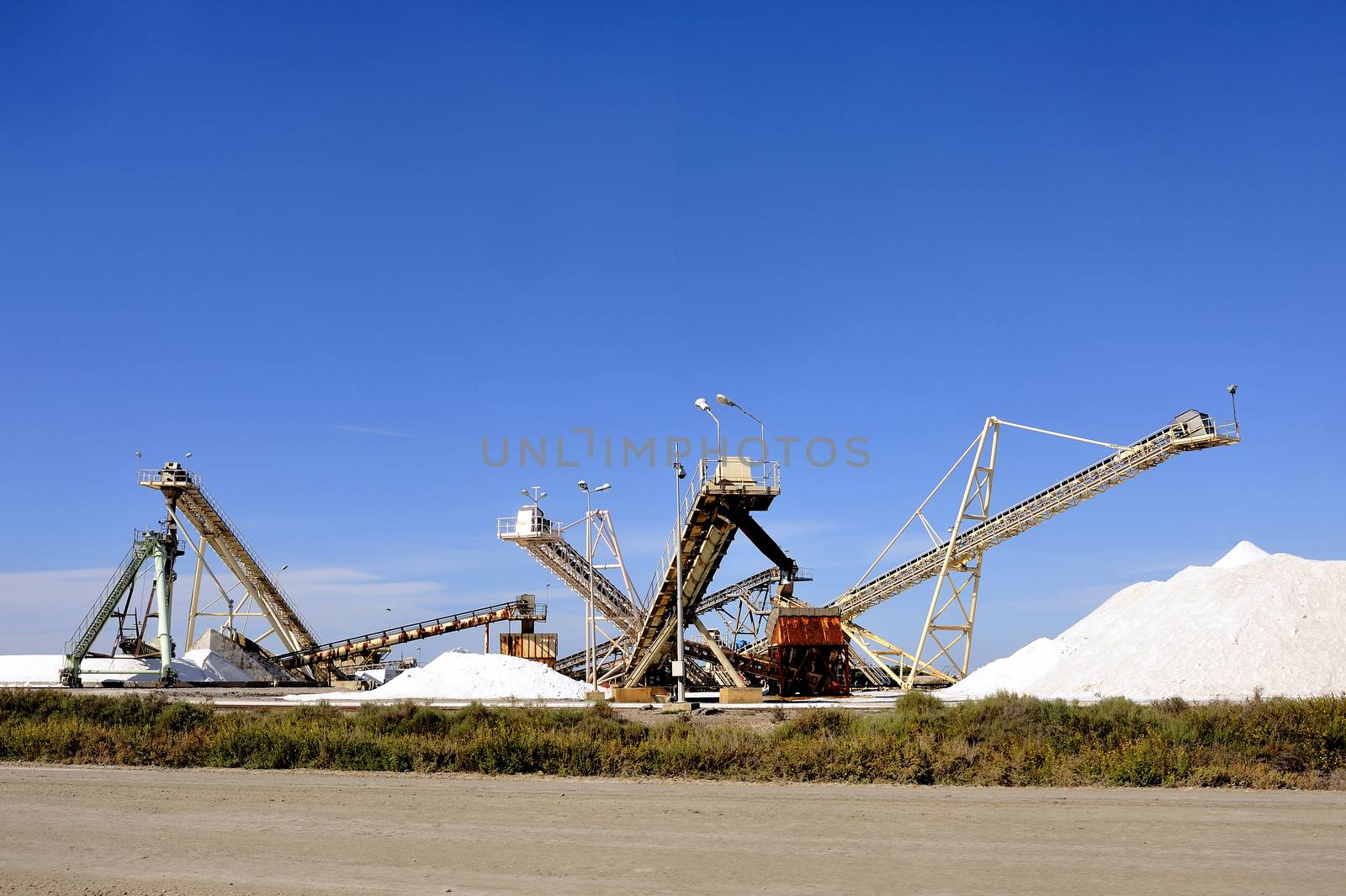 Site operating company saline Aigues-Mortes in the Camargue where stackers stack hills of sea salt.