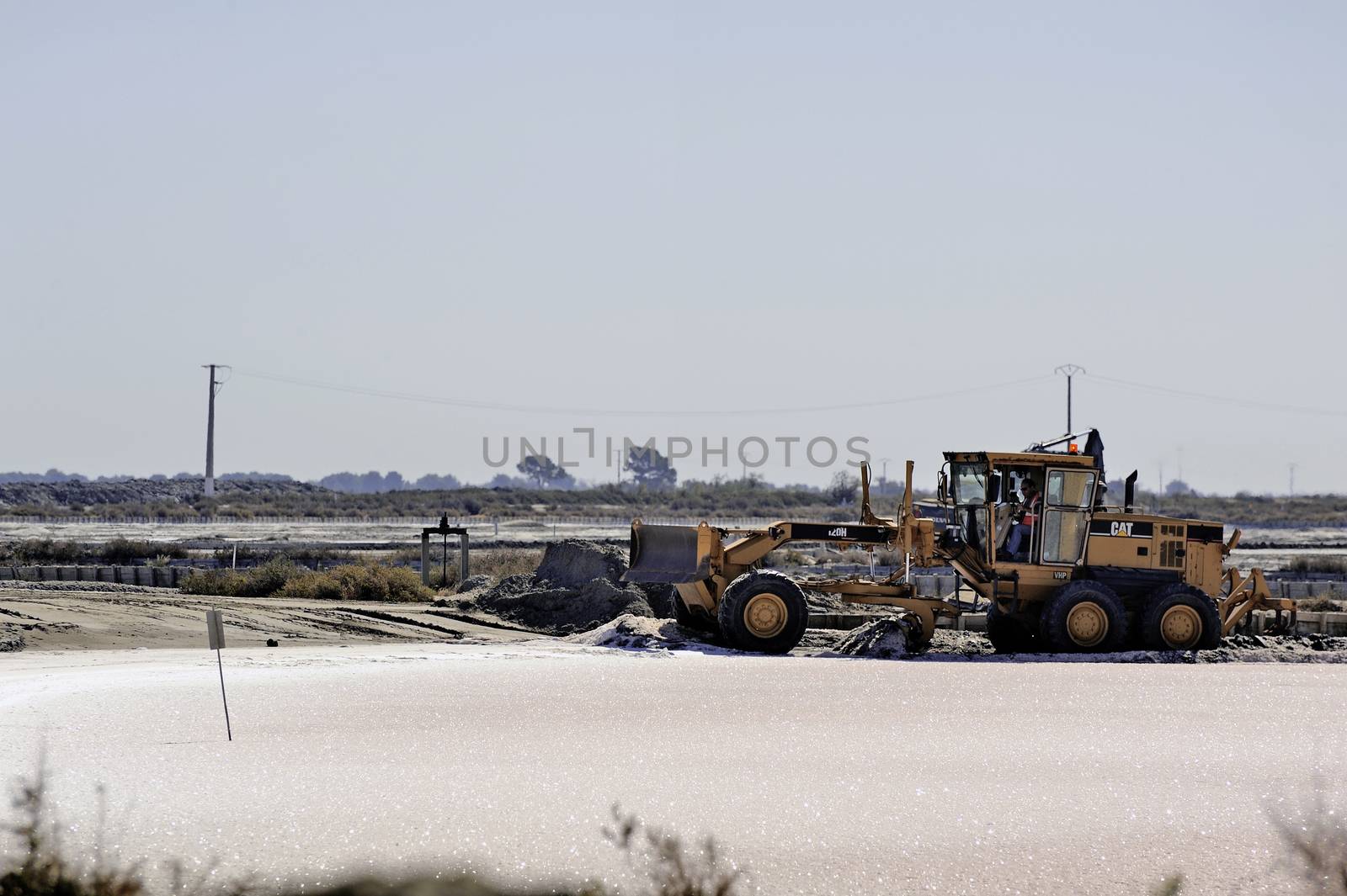 Site operating sea salt saline Aigues-Mortes with big machines and trucks working for the salt storage